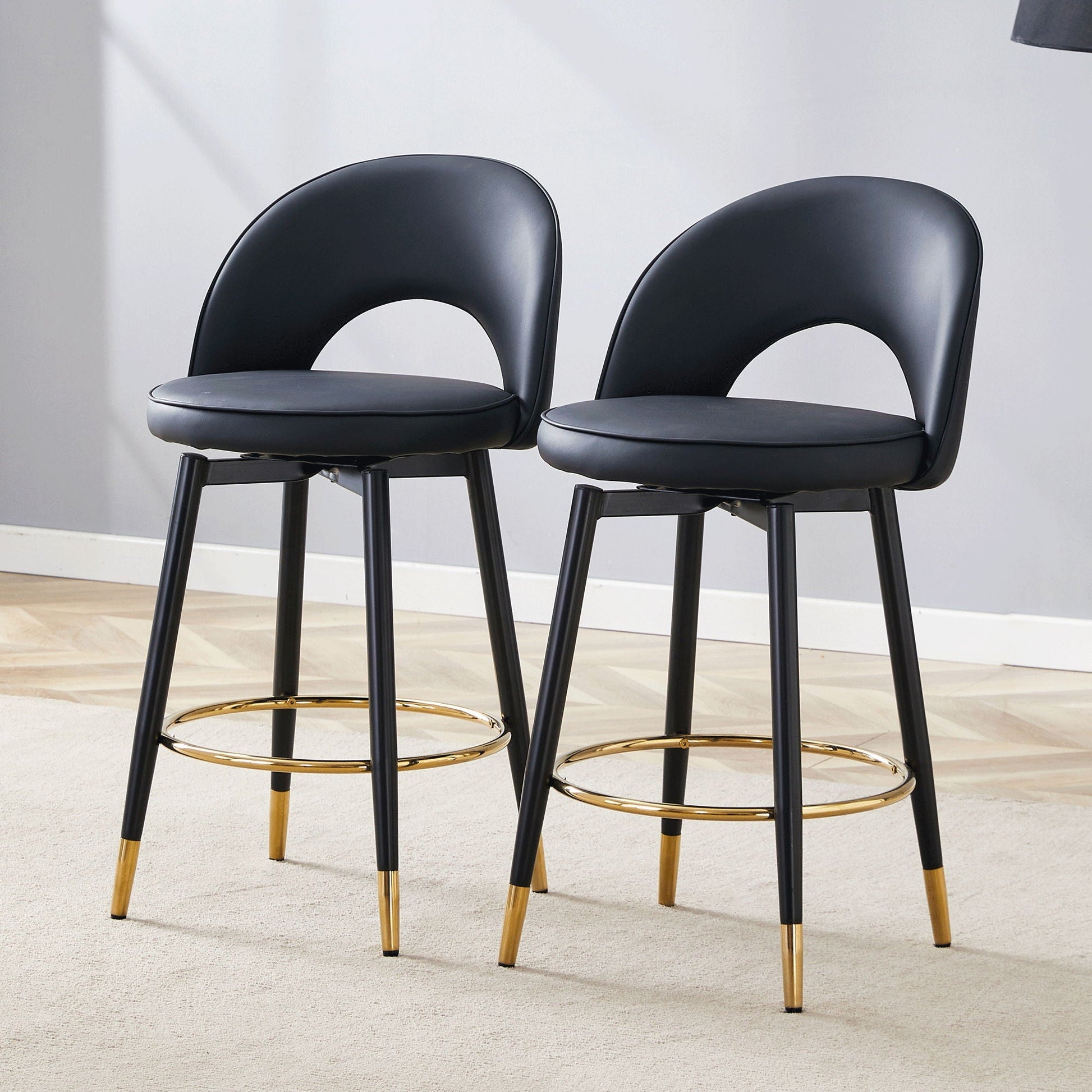 Pair of modern upholstered 360° rotatable bar stools with black seats and gold ring footrests on Tampa Home & Garden Store
