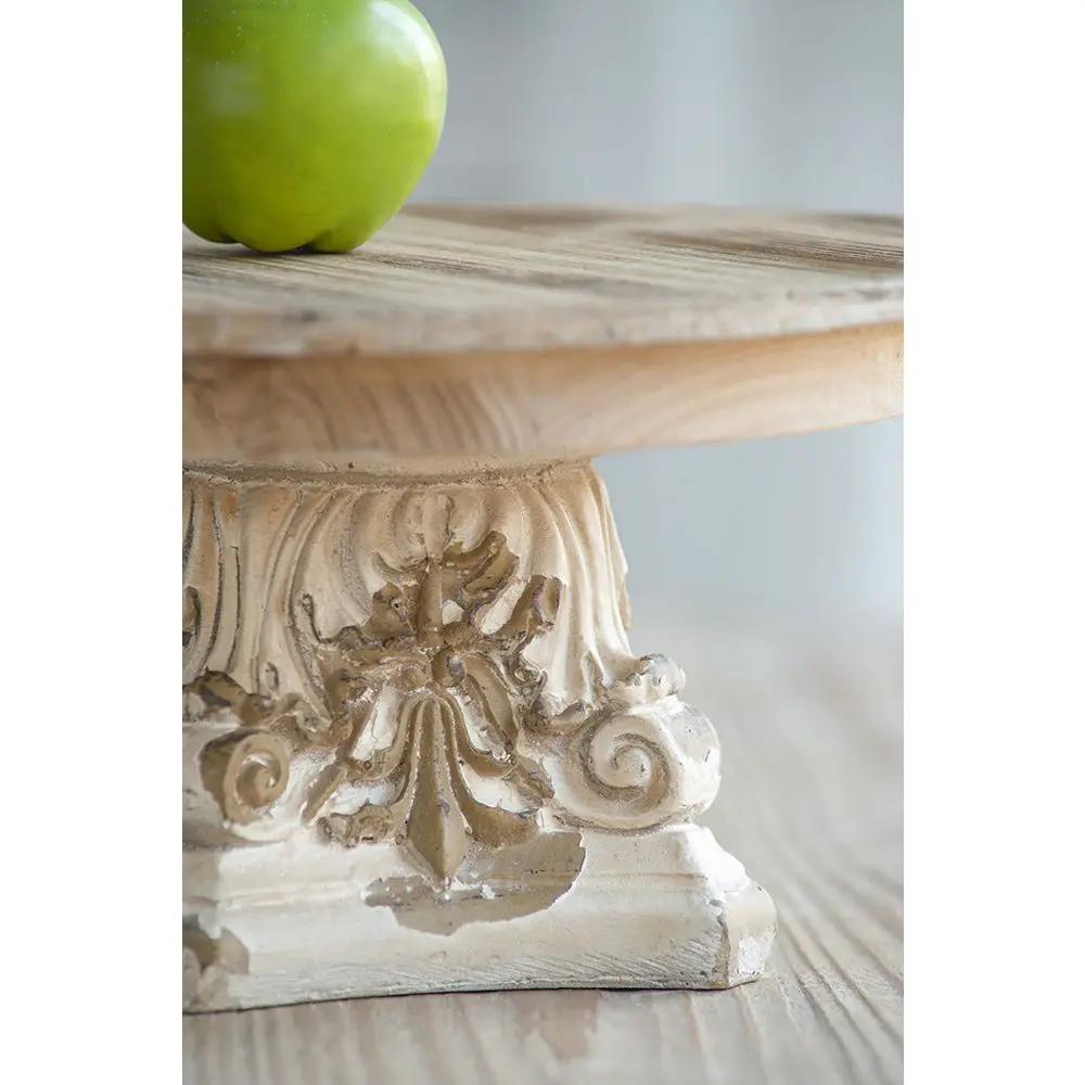 Cake stand with cream carved pedestal base and natural wood top, green apple for scale on Tampa Home & Garden Store