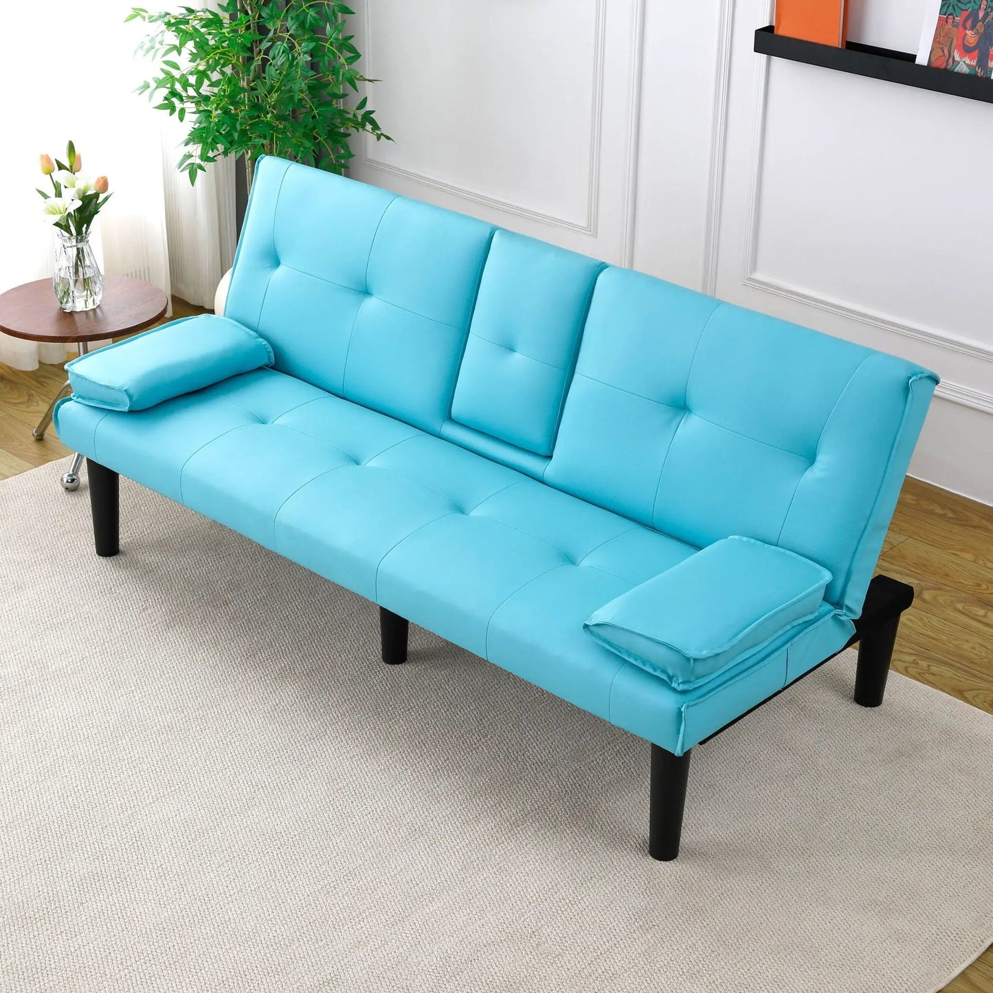 Sofa bed futon in teal faux leather with tufted sections and slim black legs on Tampa Home & Garden Store