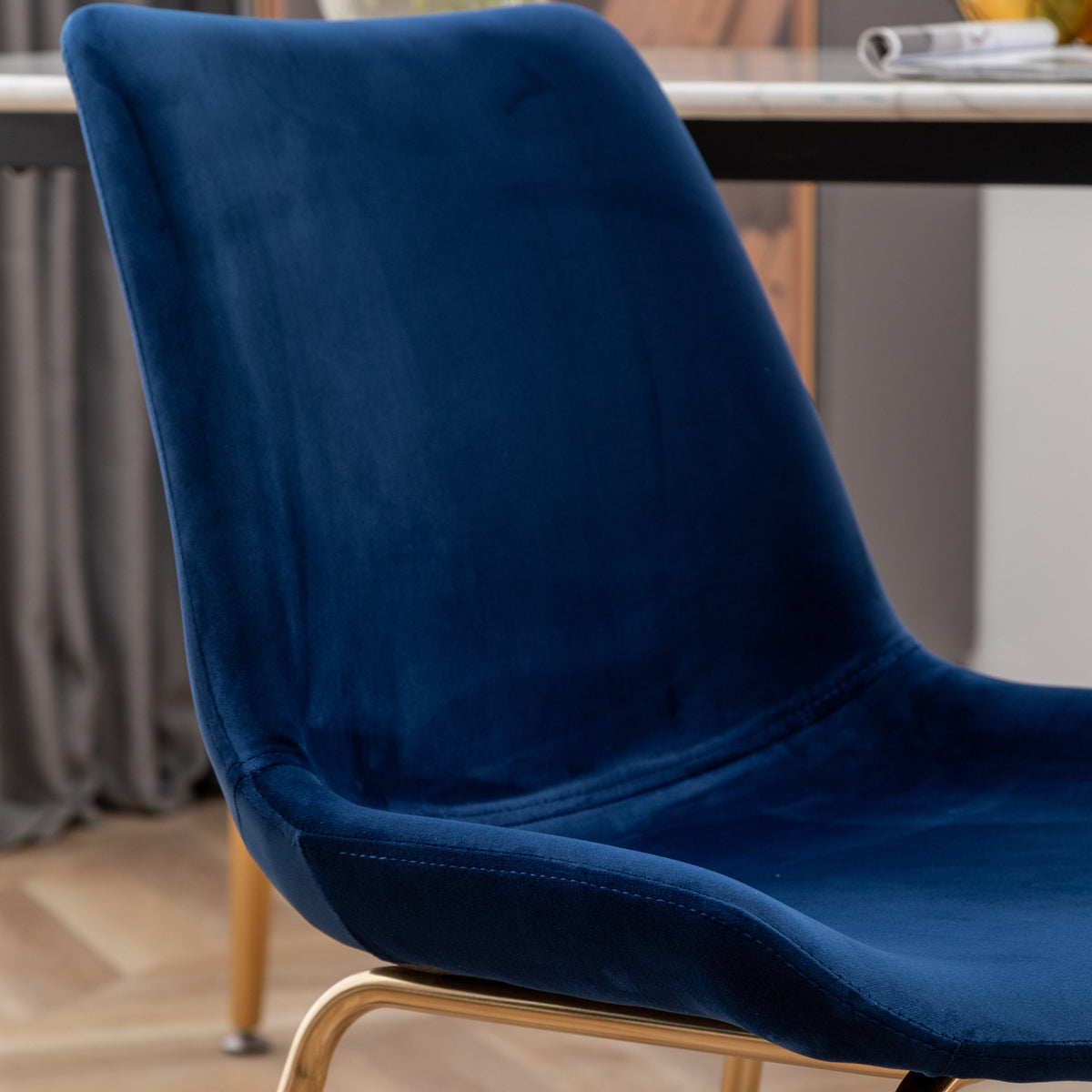 Blue velvet dining chair with curved back and light wood legs on Tampa Home & Garden Store