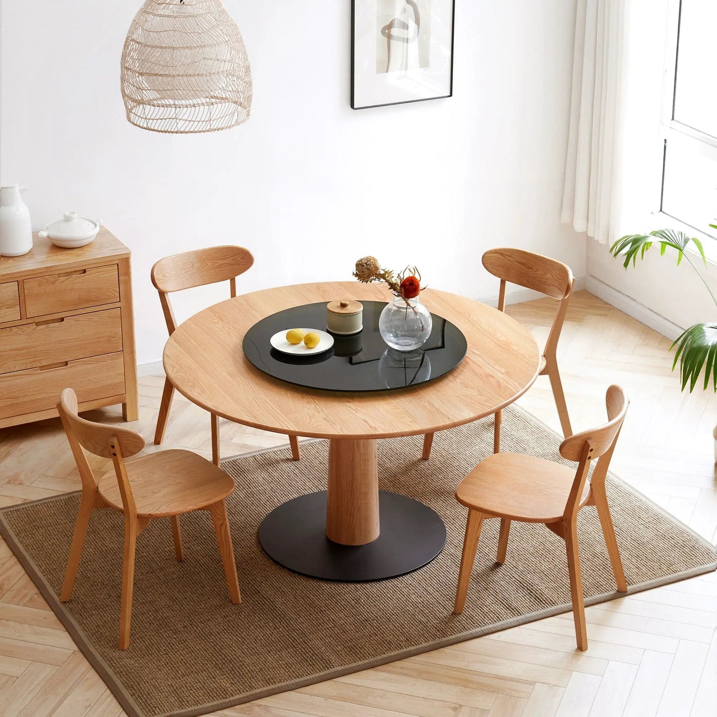 Four light oak dining chairs around a round table with a black glass centerpiece on Tampa Home & Garden Store