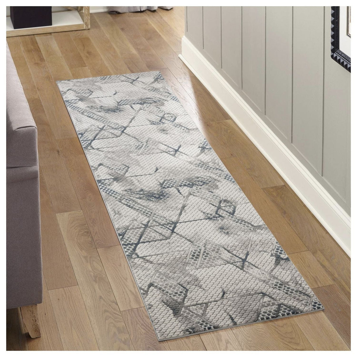 Geometric gray area rug runner with 3D texture and blue accents along a hallway on Tampa Home & Garden Store