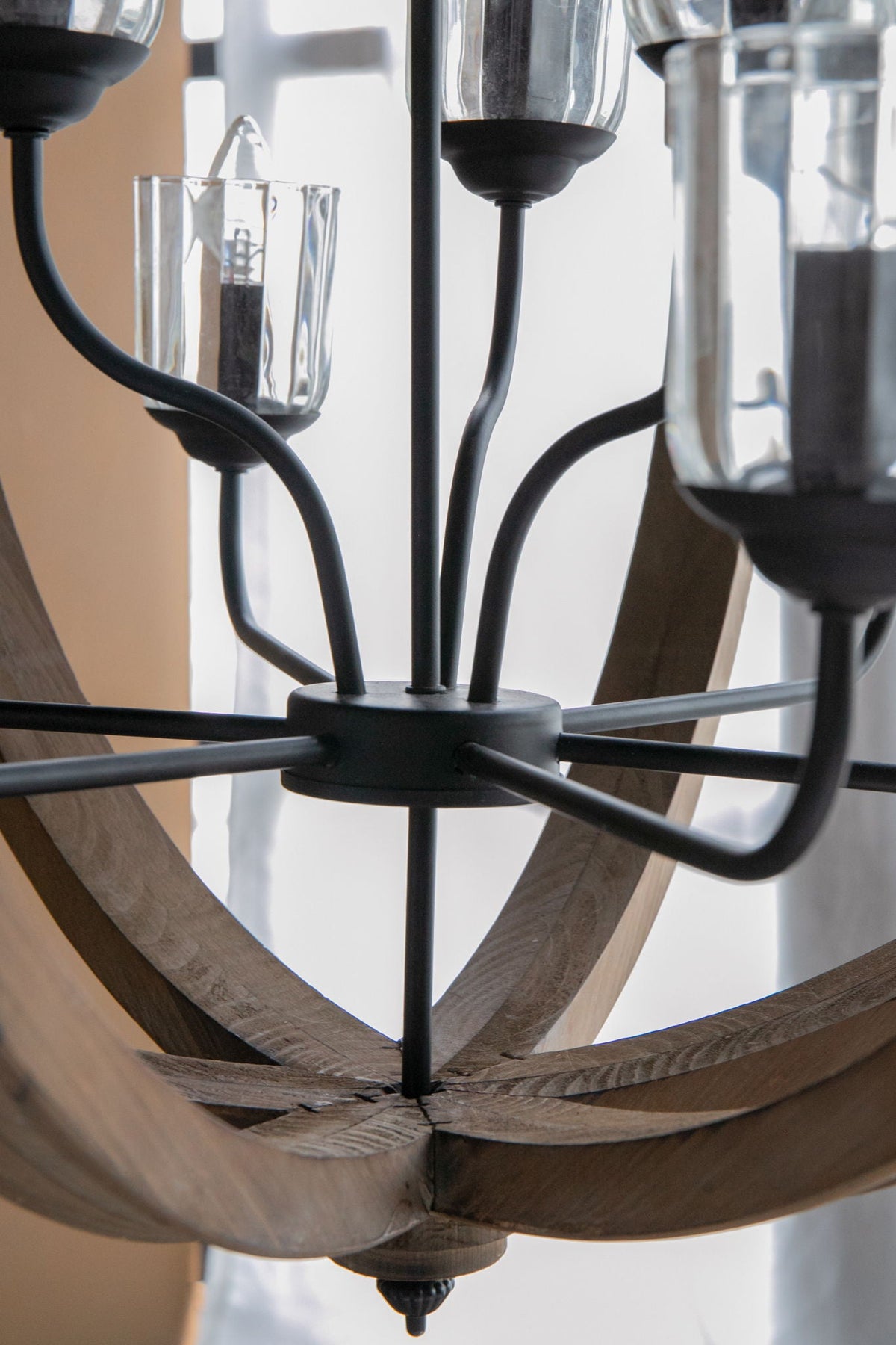 Chandelier with black metal frame and curved wooden arms featuring clear glass candle cups on Tampa Home & Garden Store