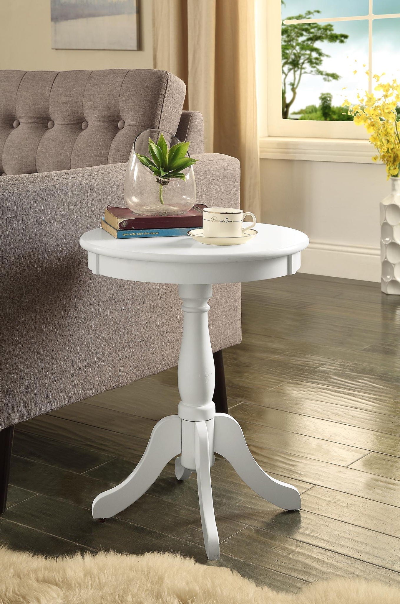 Alger white accent table with round top and turned pedestal base beside a beige tufted sofa on Tampa Home & Garden Store