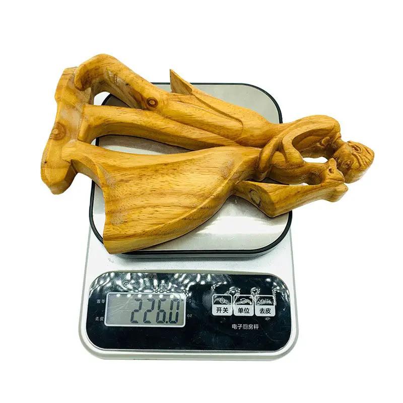 Wooden Love Eternal Valentine sculpture in natural wood finish resting on a scale on Tampa Home & Garden Store