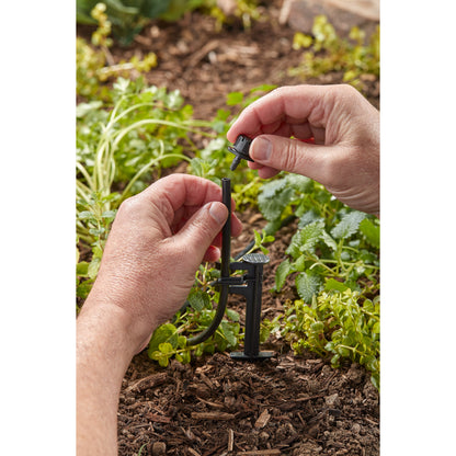 Orbit 1/4 in black drip distribution tubing with connector being installed in garden irrigation on Tampa Home & Garden Store