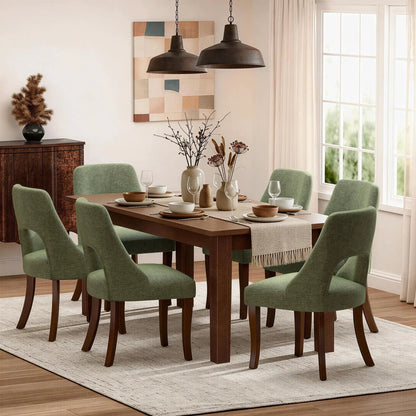 Six green upholstered dining chairs with curved legs around a wooden table in a dining room on Tampa Home & Garden Store