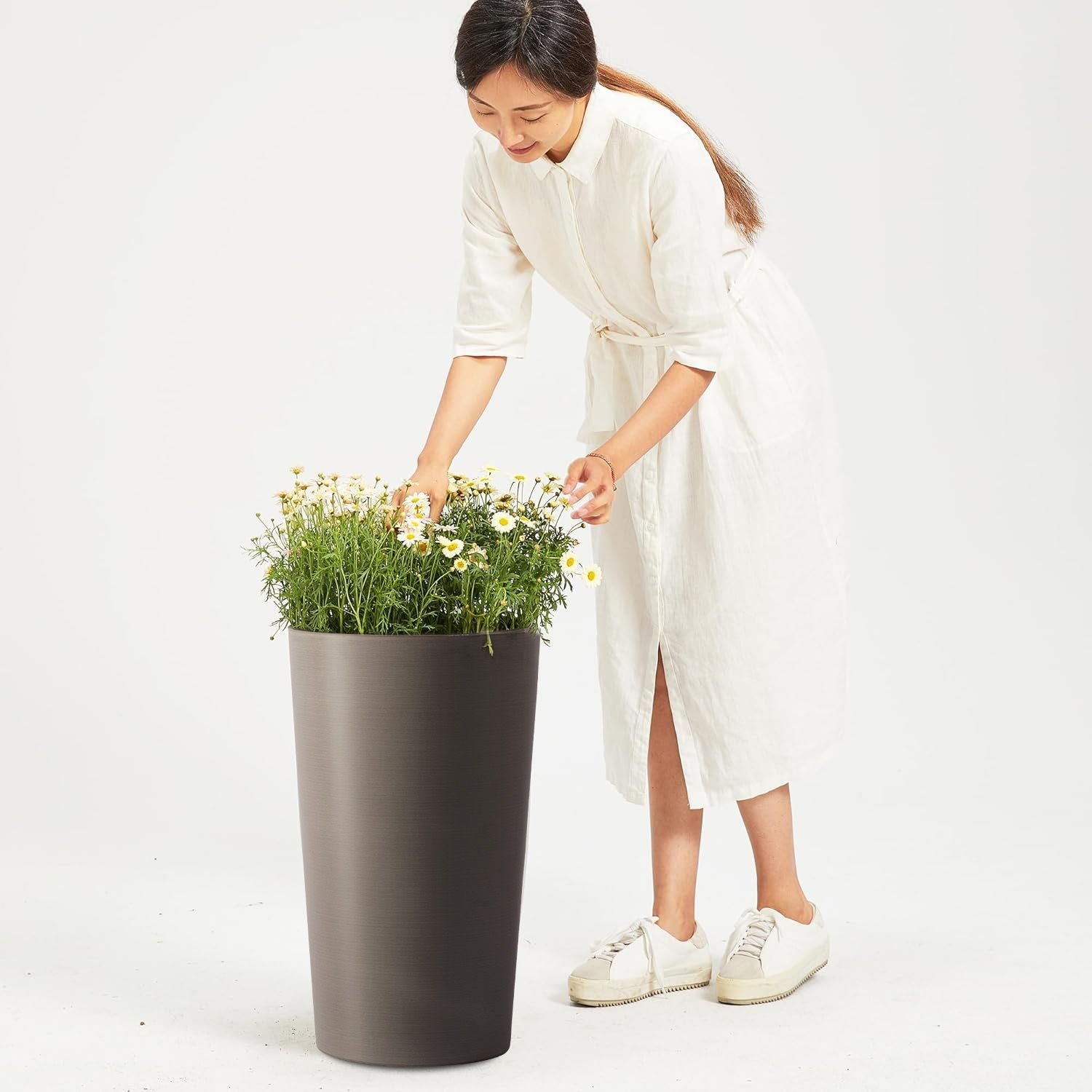 Planter For Outdoor dark gray planter with white daisies, tended by a woman in a white dress on Tampa Home & Garden Store