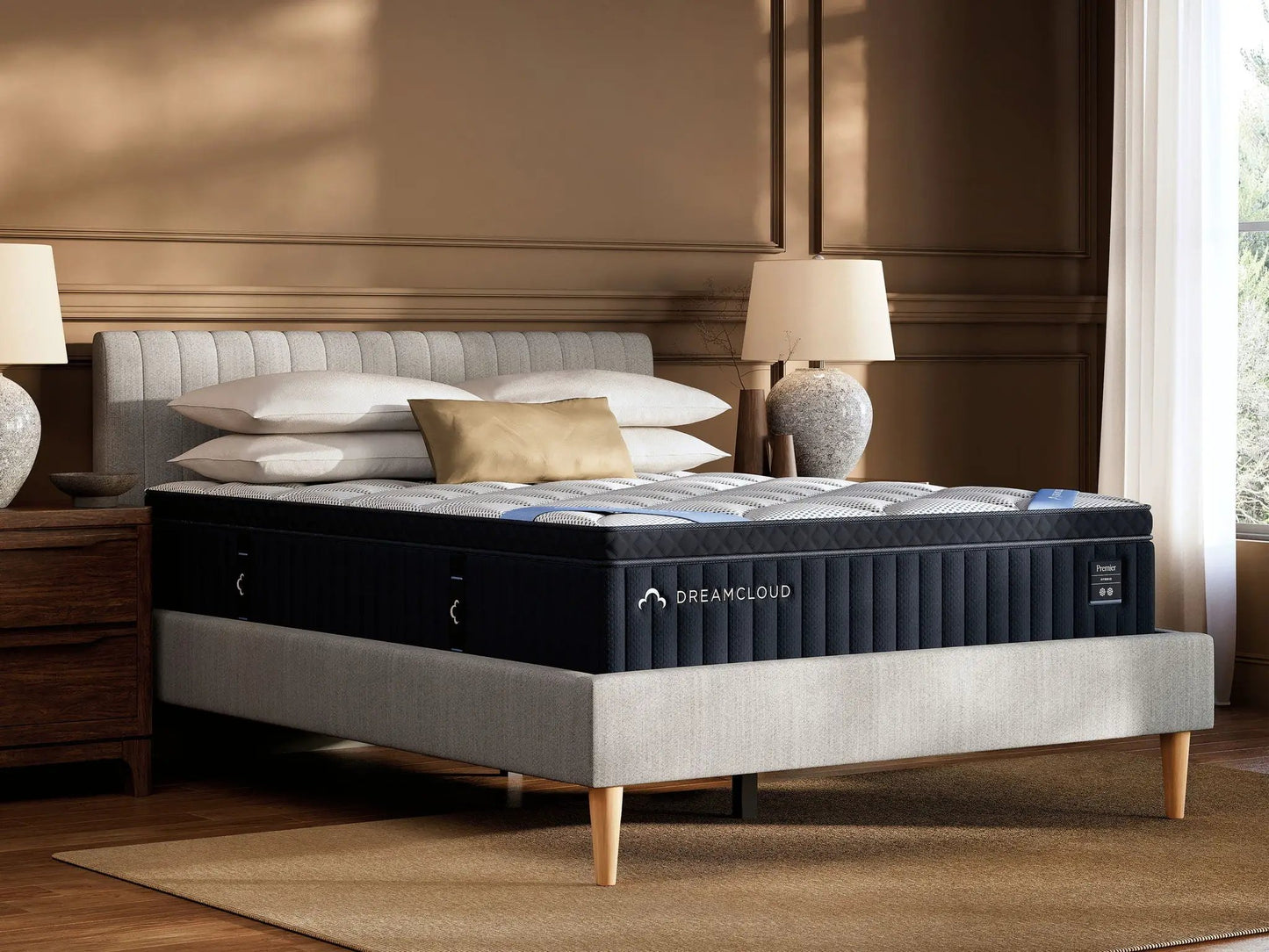 DreamCloud Premier Hybrid mattress on a light gray upholstered bed with beige pillows on Tampa Home & Garden Store