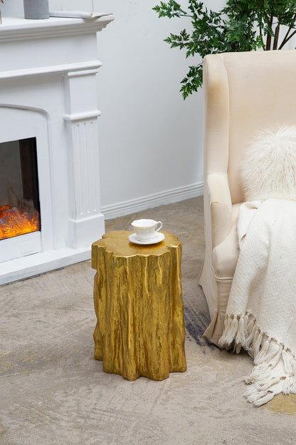 Unique golden tree trunk stool with antique gold distressed finish beside a beige armchair on Tampa Home & Garden Store