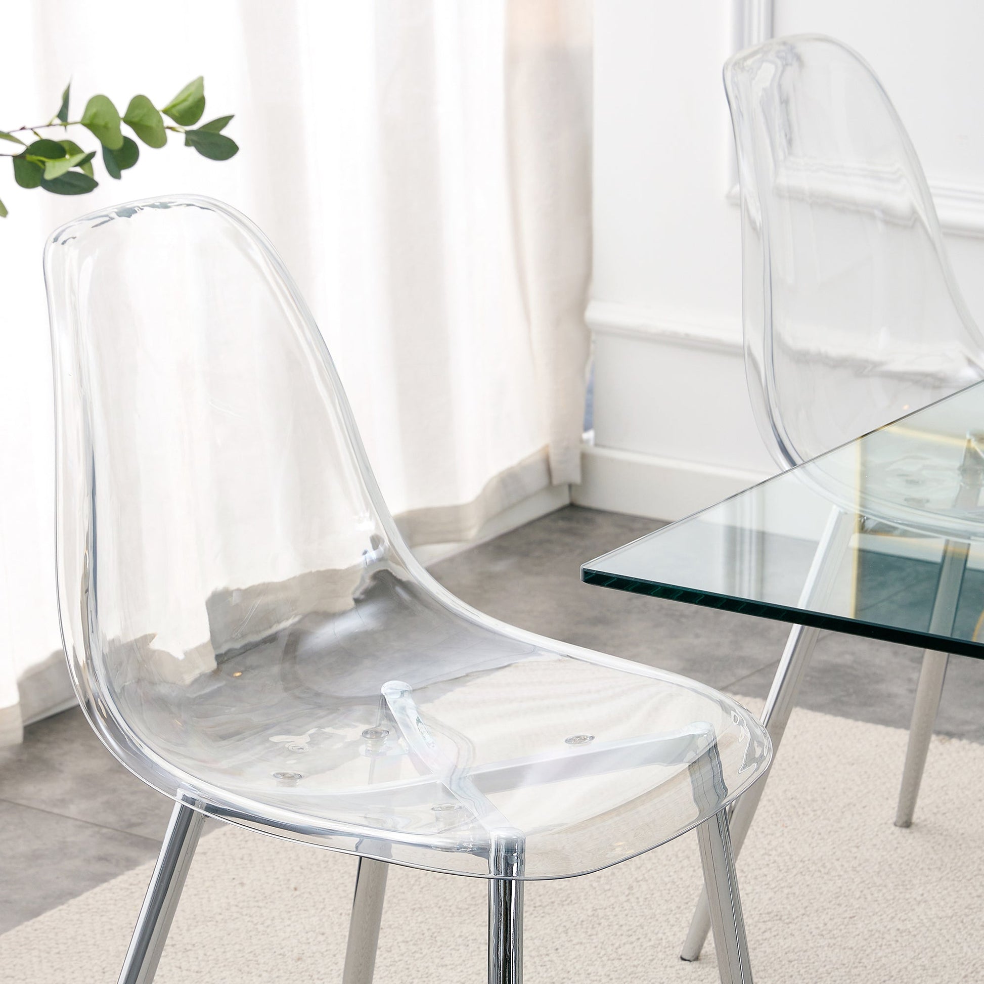 Modern Minimalist Transparent Dining Chairs in clear acrylic beside a glass dining table on Tampa Home & Garden Store