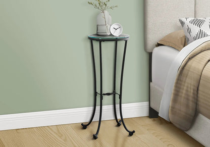 Round glass-top accent side table with black metal tripod legs, displaying a vase and clock on Tampa Home & Garden Store