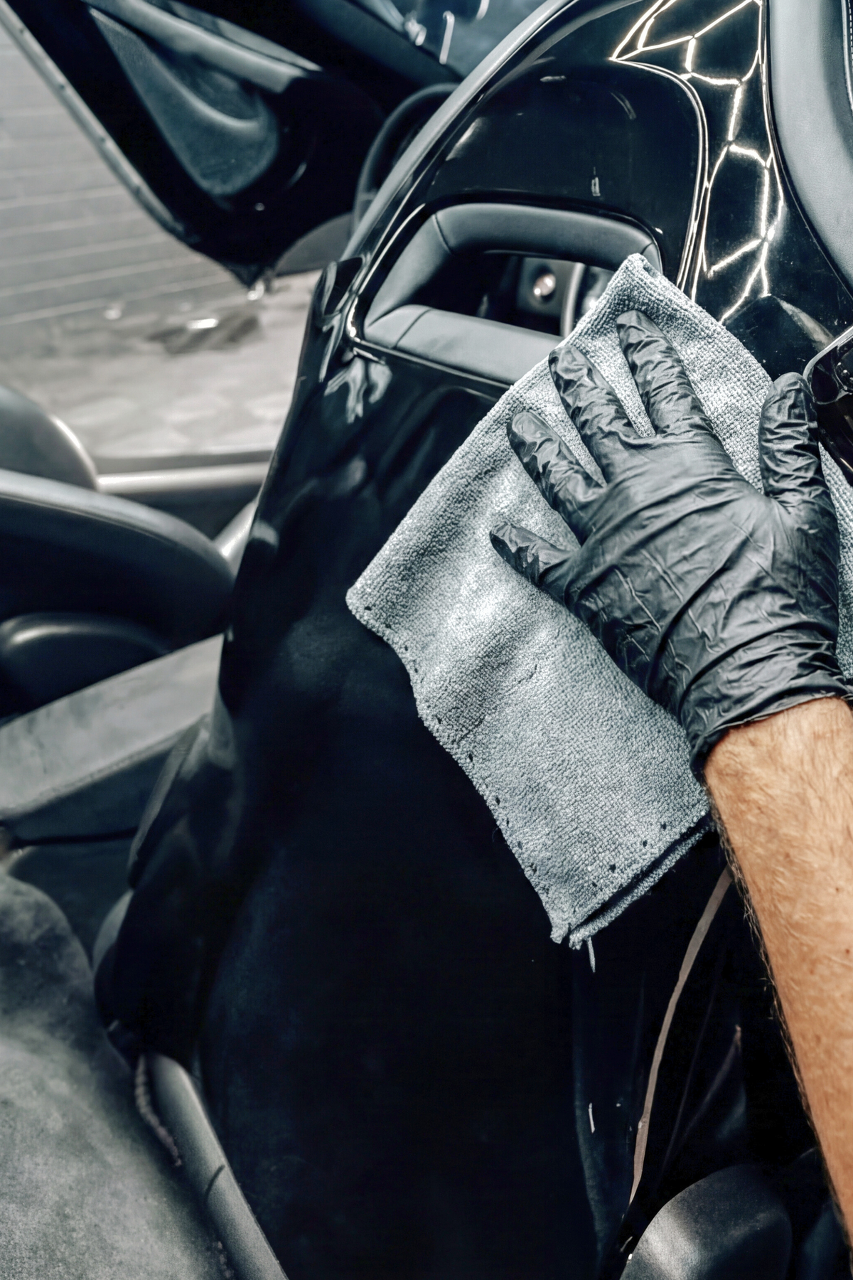 BLACKLINE CARBON CLOTH microfiber wipe used on a glossy black car door panel by gloved hand on Tampa Home & Garden Store