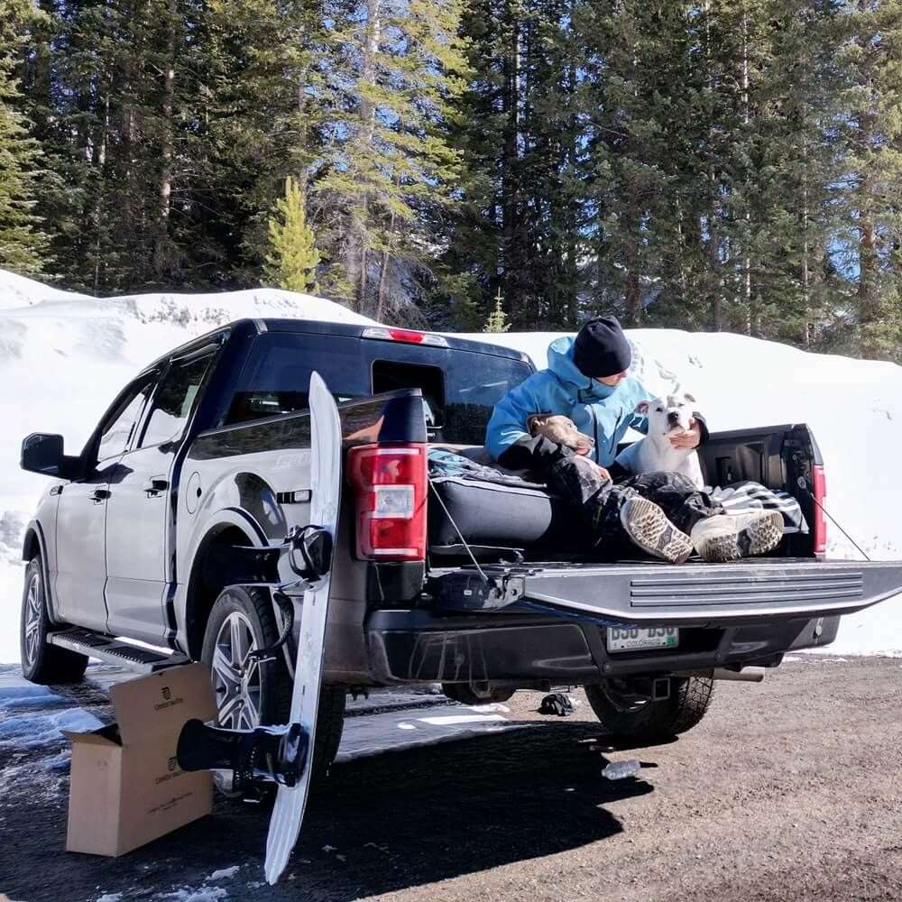 6ft Isuzu Truck Bed Air Mattress in pickup bed with a person and a dog, outdoor scene on Tampa Home & Garden Store