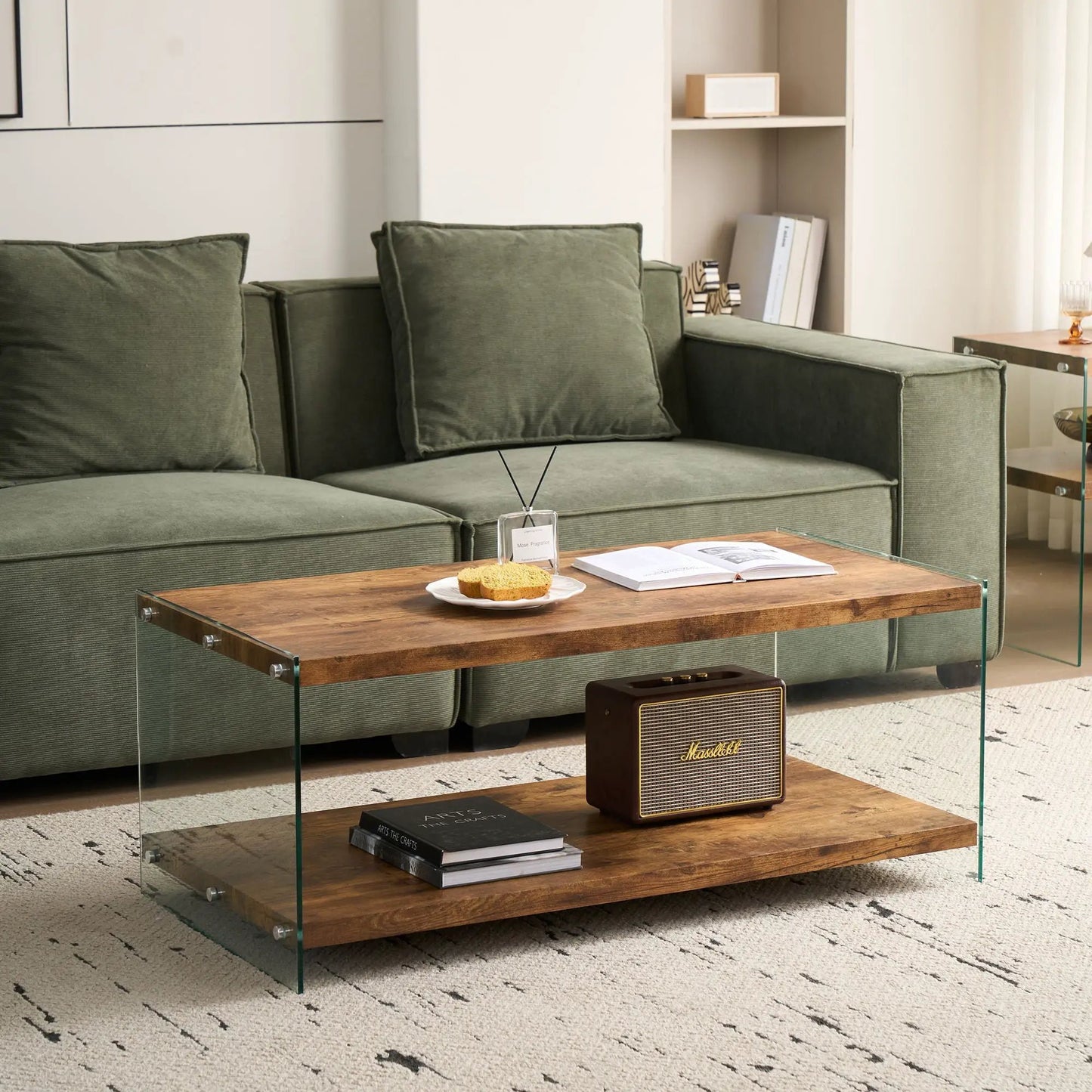 Durable living room table with warm wood top and clear glass sides in front of a green sofa on Tampa Home & Garden Store