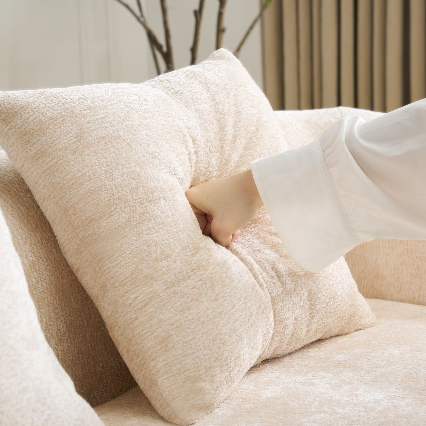 Beige plush towels stacked with a hand resting nearby, soft terry texture in a cozy setting on Tampa Home & Garden Store