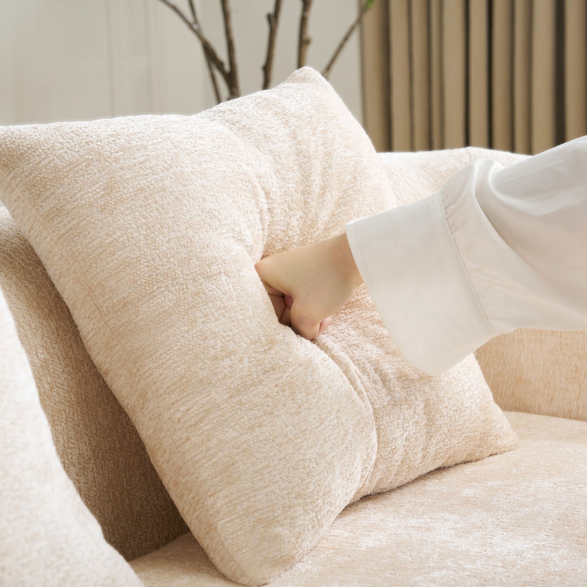 Beige plush towels stacked with a hand resting nearby, soft terry texture in a cozy setting on Tampa Home & Garden Store
