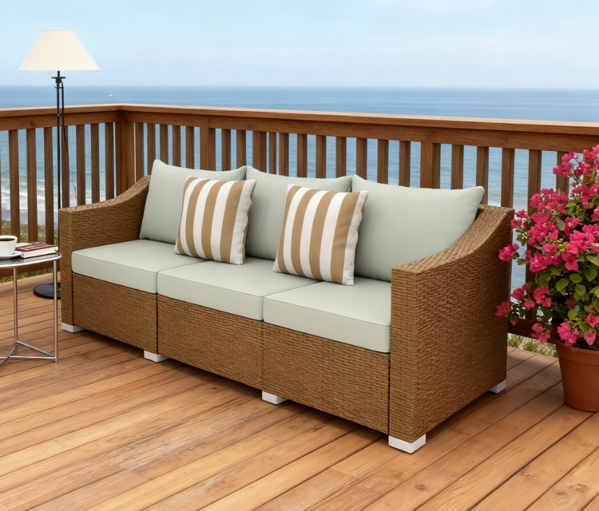 Rattan wicker outdoor sofa with cream cushions and striped pillows on a wooden deck on Tampa Home & Garden Store