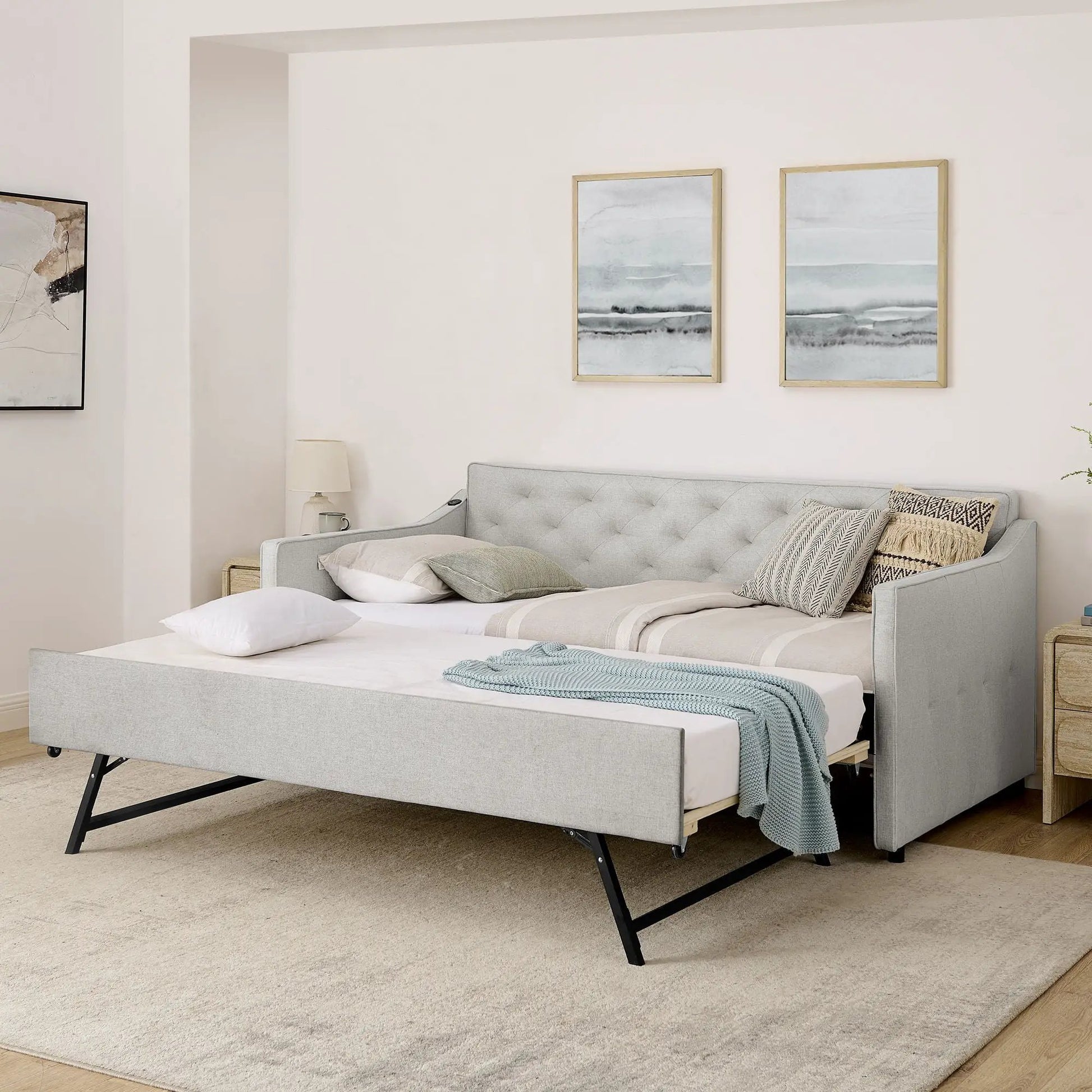 Gray upholstered daybed with pop-up trundle on black metal legs and decorative pillows on Tampa Home & Garden Store