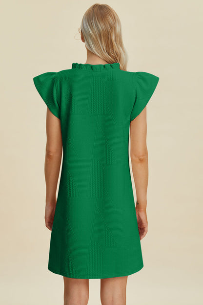 Green textured cap-sleeve dress with geometric panel pattern, back view on Tampa Home & Garden Store