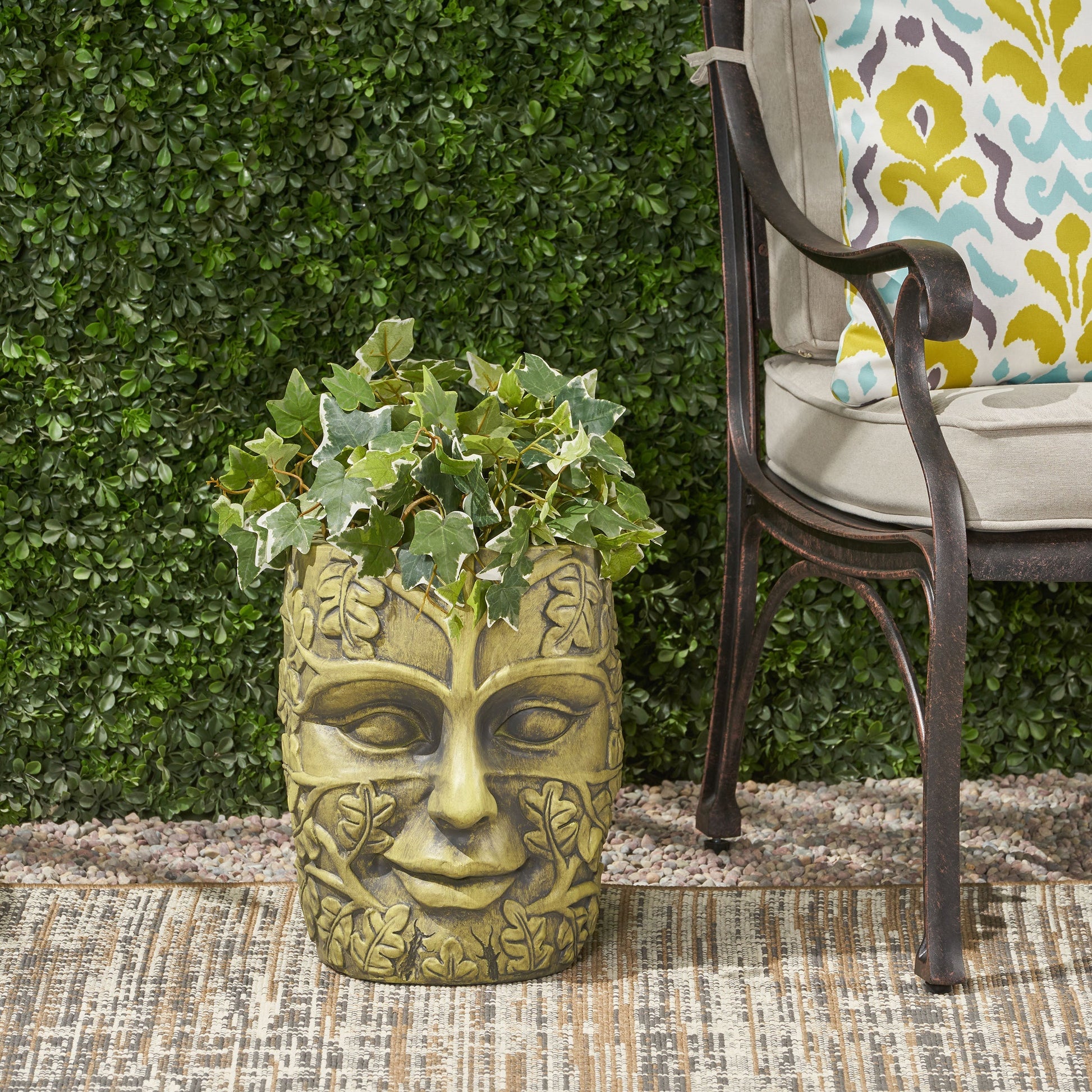 Garden urn planter with carved face motif in antique gold finish, ivy spilling over top on Tampa Home & Garden Store
