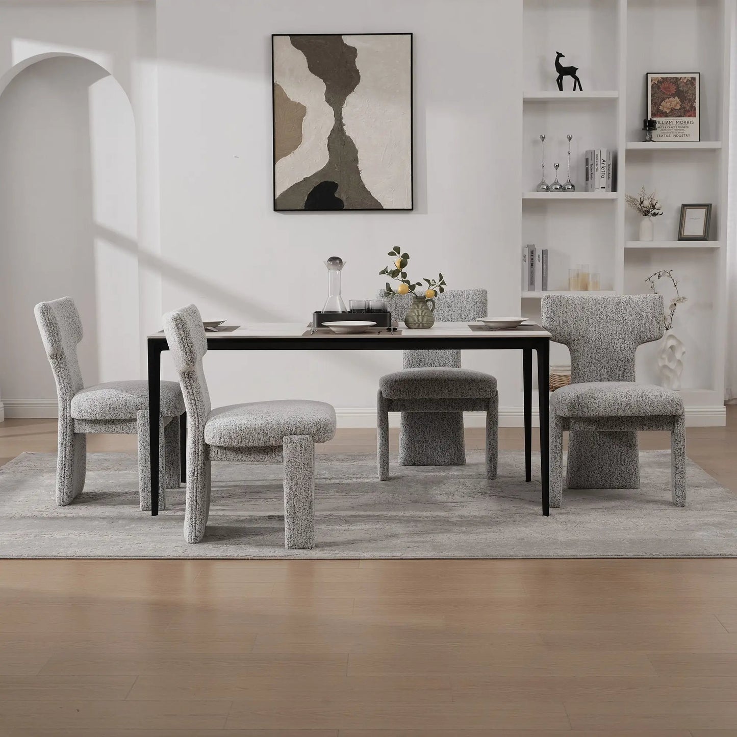 Armless curved-back accent chairs in light gray textured fabric with black legs at dining table on Tampa Home & Garden Store