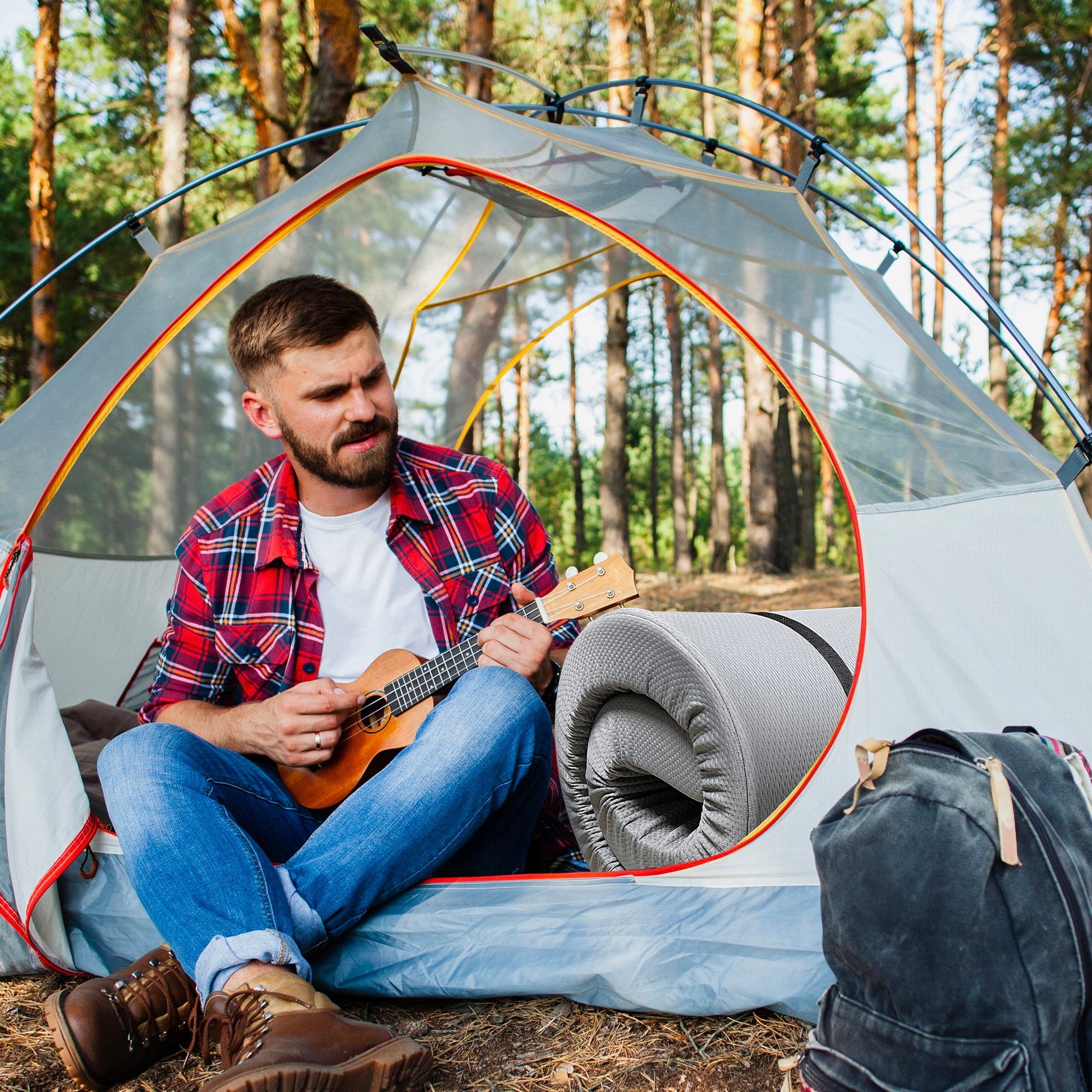 Memory Foam Camping Mattress gray with water resistant zipper cover inside a tent, man playing guitar on Tampa Home & Garden Store