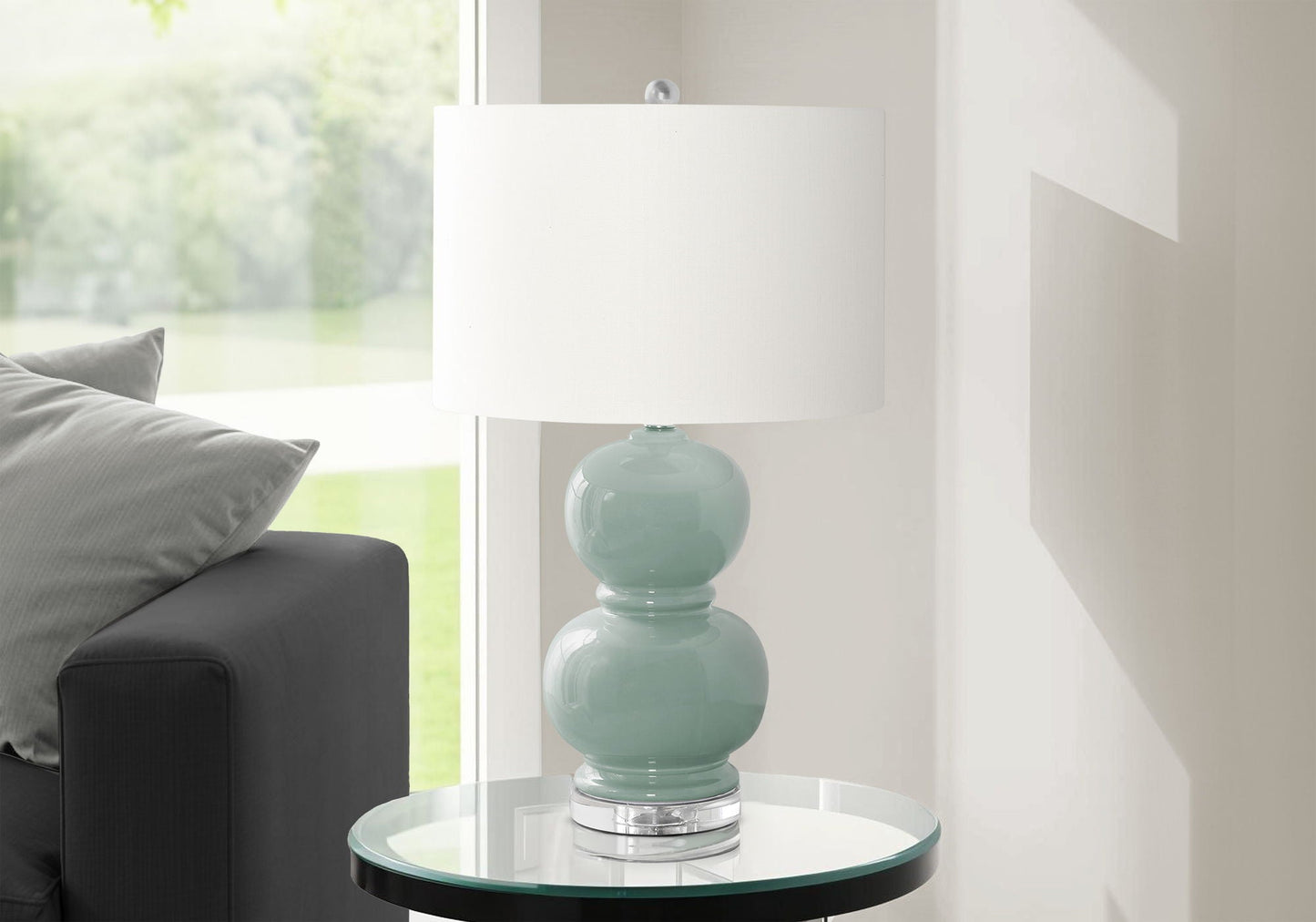 Blue ceramic table lamp with stacked-sphere base and white drum shade on glass round table on Tampa Home & Garden Store