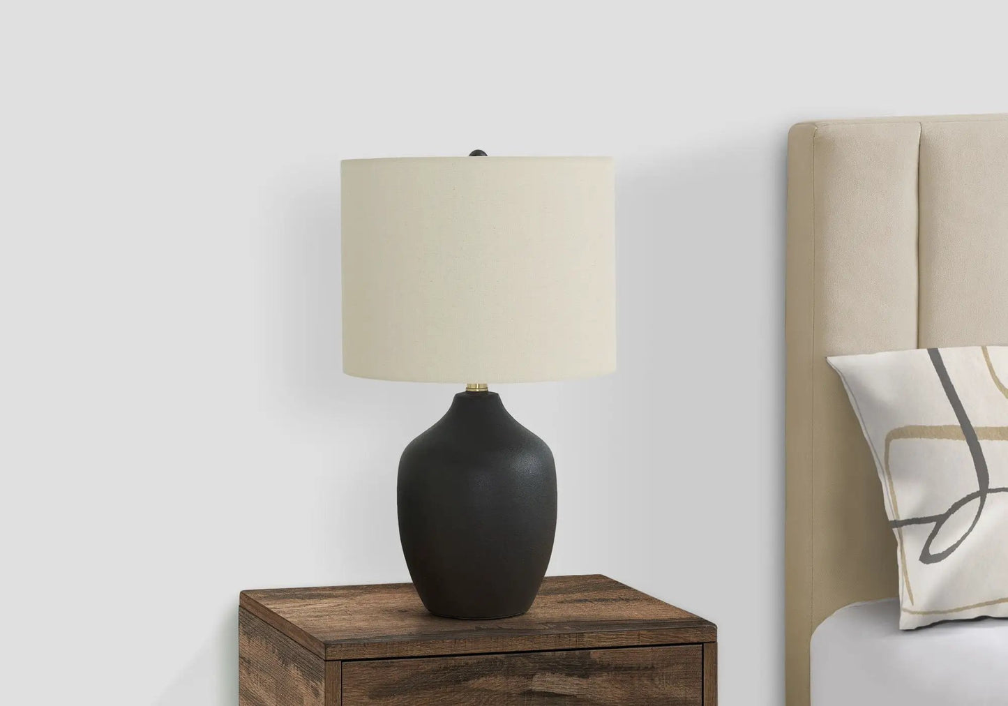 Table lamp with black ceramic base and cream fabric shade on a wood nightstand on Tampa Home & Garden Store
