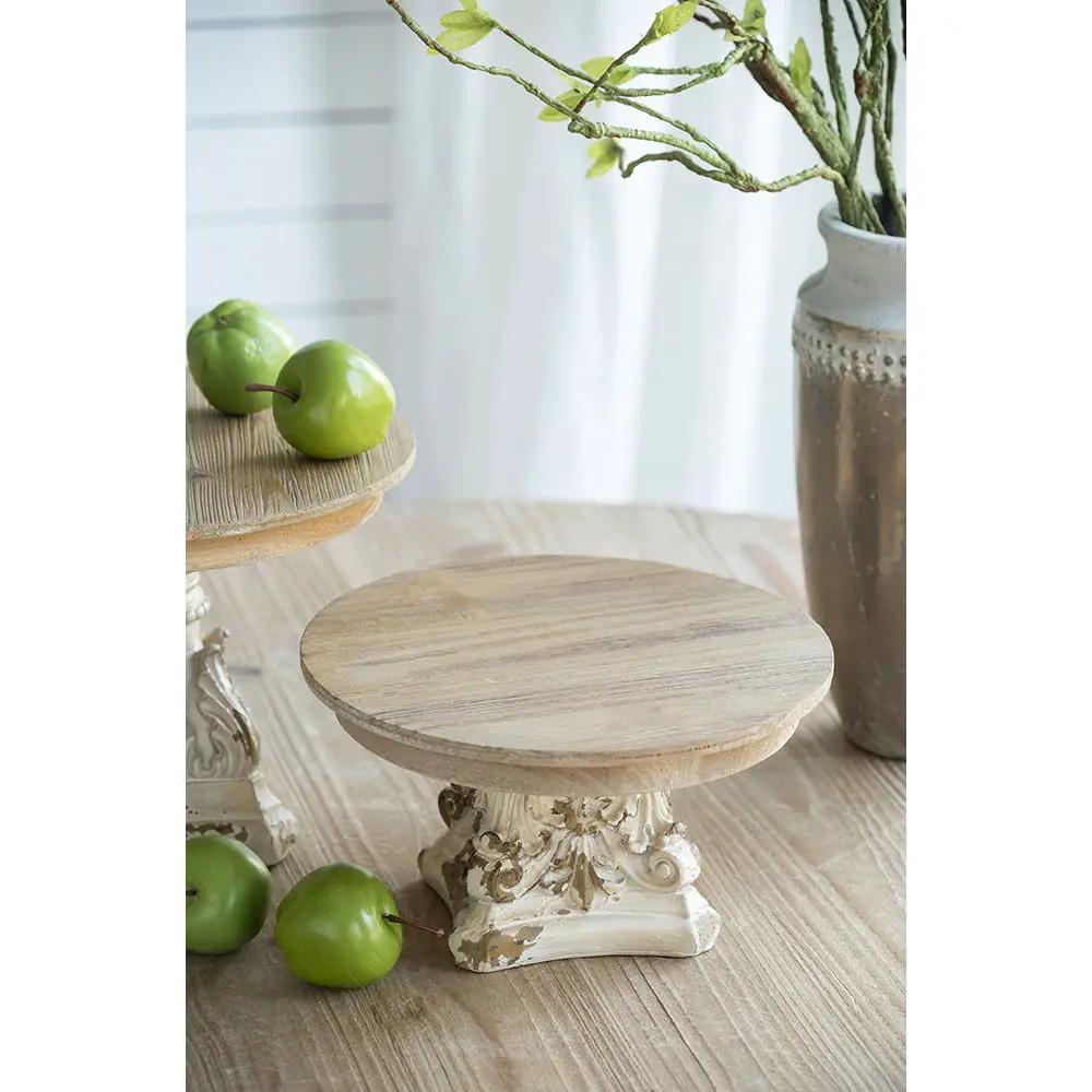 Two cake stands with magnesium bases, cream/brown wood tops, ornate pedestals on Tampa Home & Garden Store