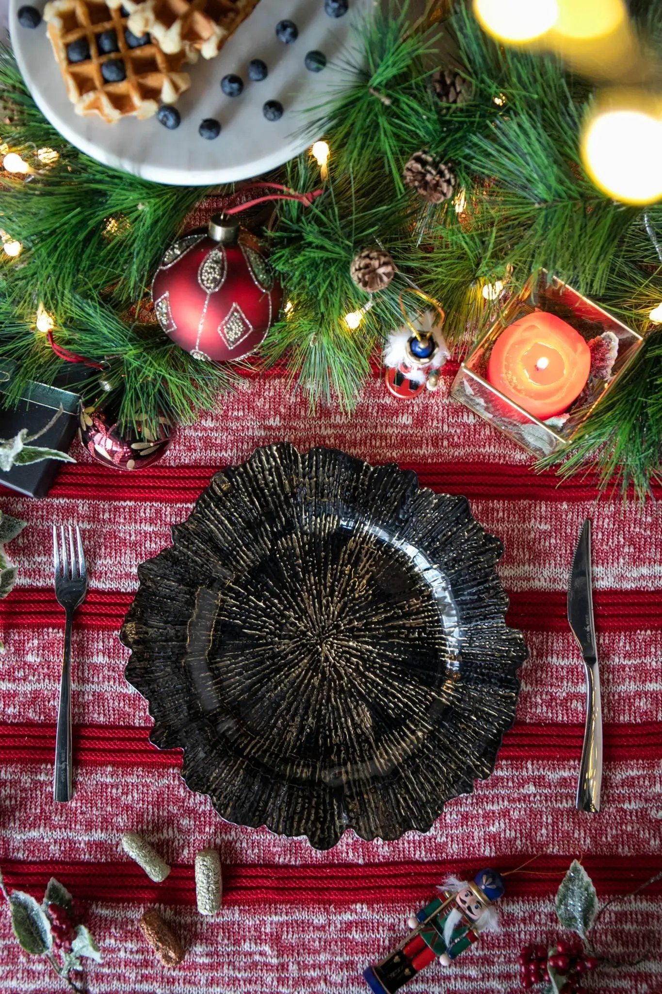 Plastic charger plate set of 8, black textured sunburst design on red holiday table on Tampa Home & Garden Store