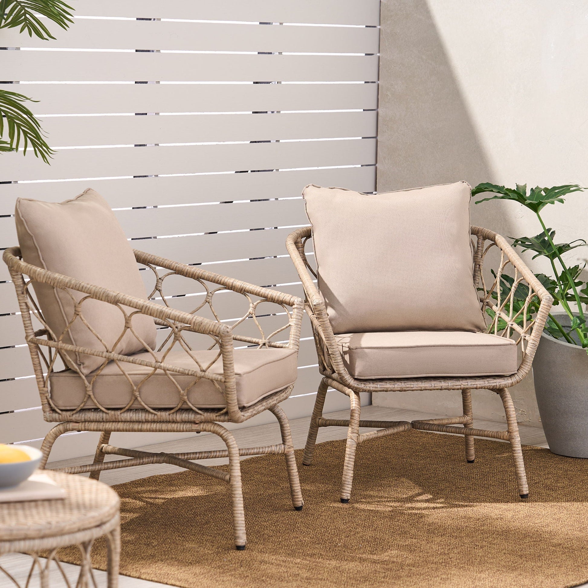 Bruce Outdoor Club Chair Set with water resistant cushions, two beige wicker chairs on a rug on Tampa Home & Garden Store