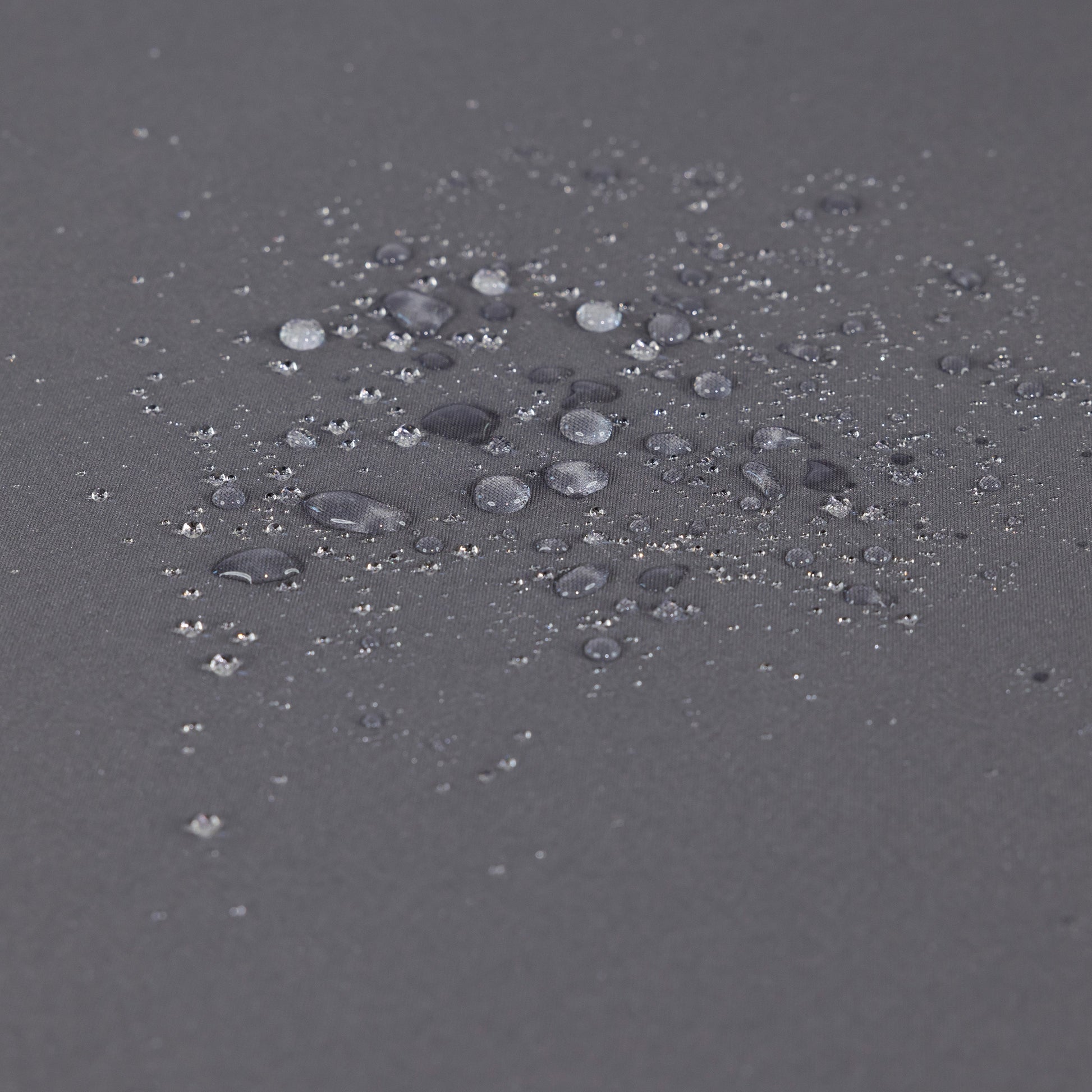 Outdoor chaise lounge fabric close-up in gray with scattered water droplets on surface on Tampa Home & Garden Store