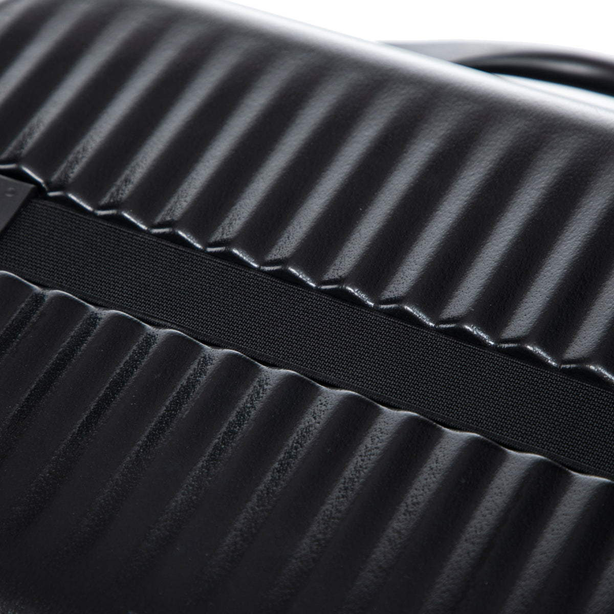 Black ABS luggage shell close-up with ribbed texture and fabric strap, from HouseOfZazla on Tampa Home & Garden Store