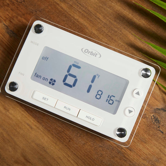 Orbit Irrigation 7-Day Programmable Thermostat with clear protective cover on wood surface on Tampa Home & Garden Store