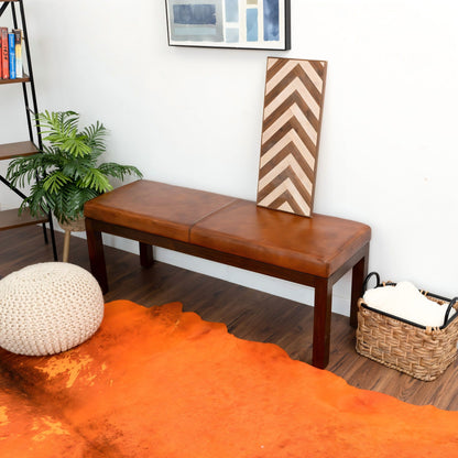 Antique brown upholstered bench with solid wood frame and leather seat on hardwood floor on Tampa Home & Garden Store