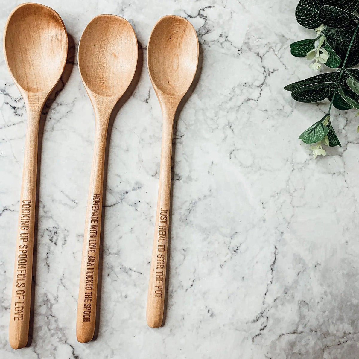 Wooden spoon set by Gia Roma with engraved handle messages, three spoons on marble surface on Tampa Home & Garden Store