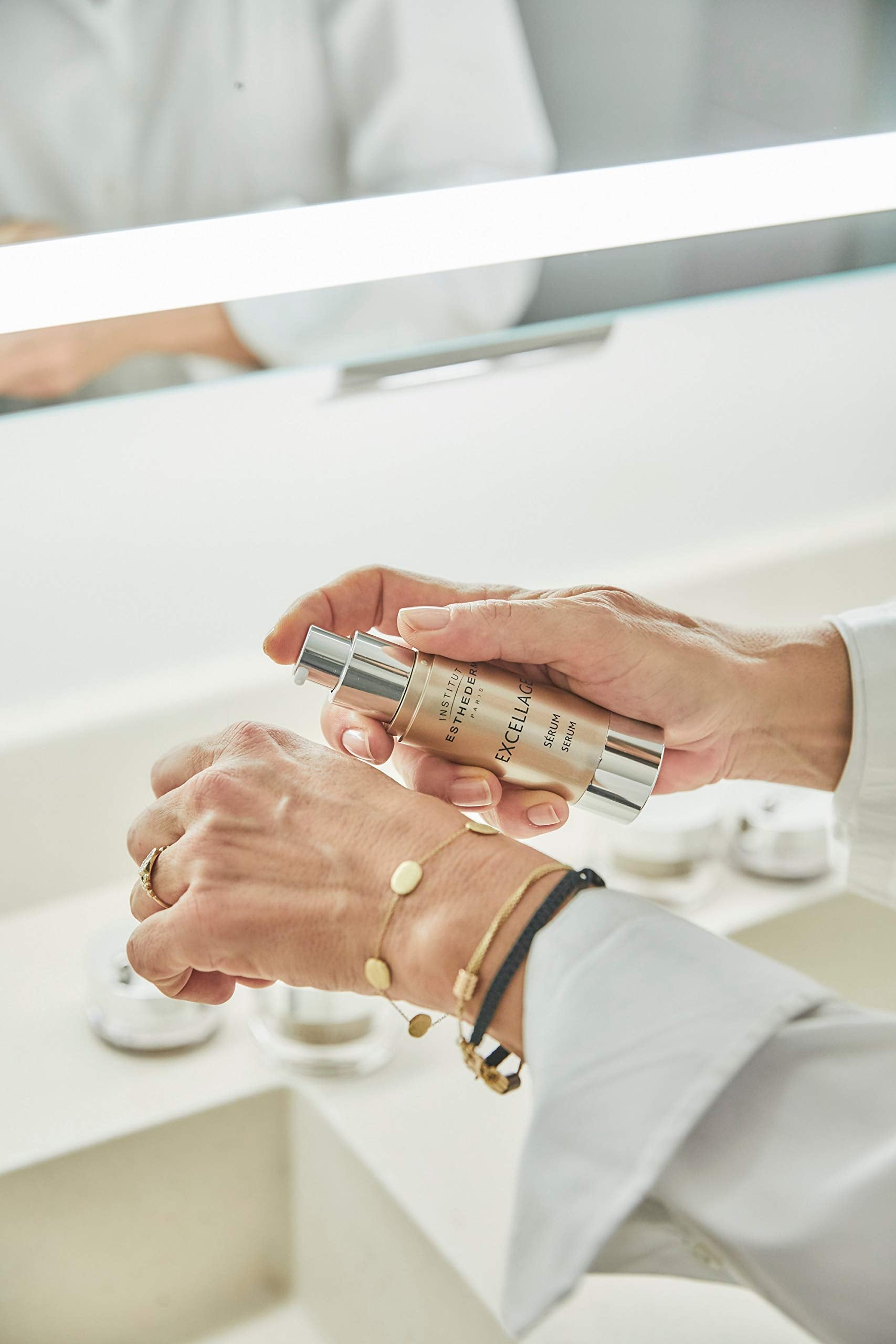 Institut Esthederm Excellage serum 30ml beige pump bottle in hand on Tampa Home & Garden Store