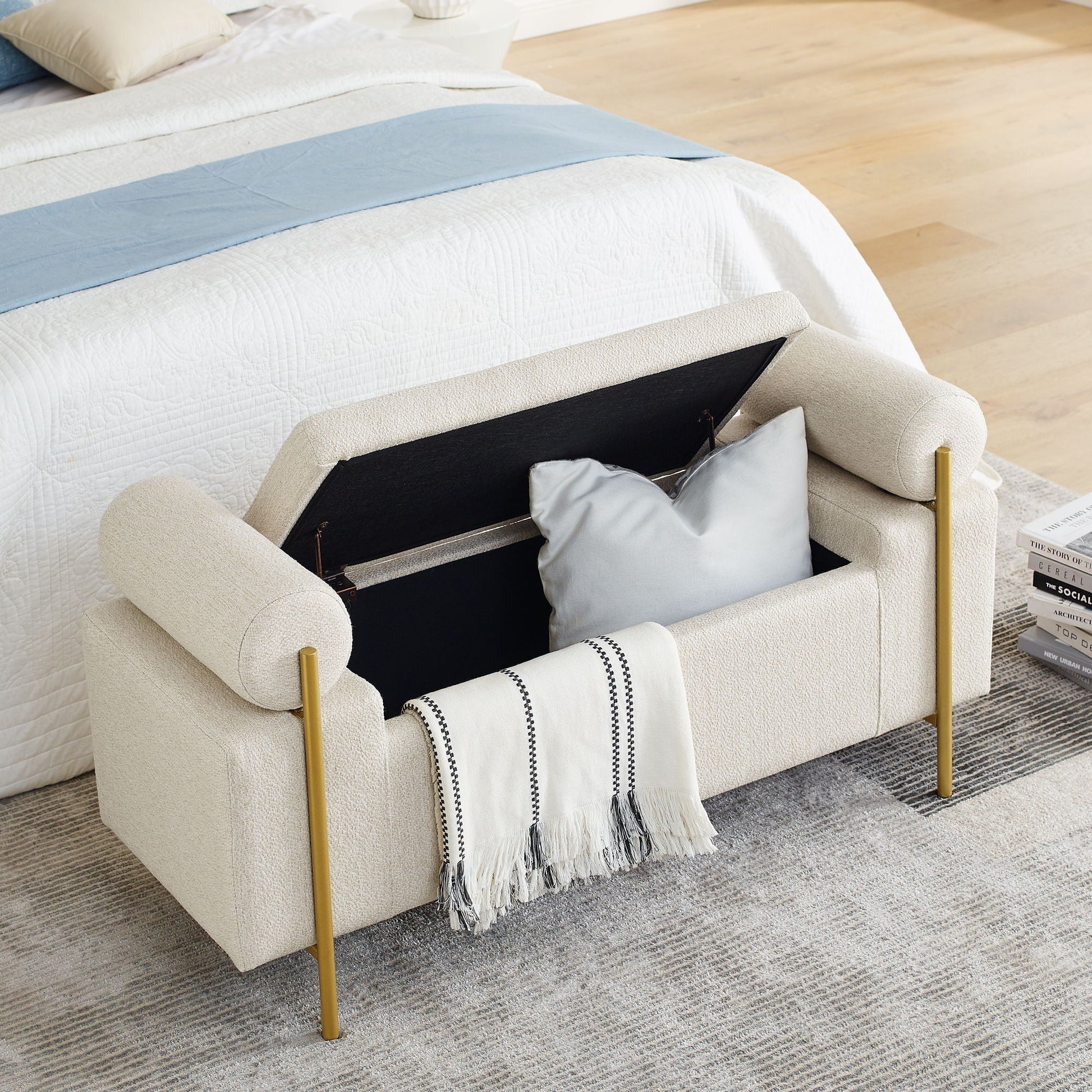 Elegant upholstered storage bench with cylindrical arms and gold iron legs in tan fabric at foot on Tampa Home & Garden Store