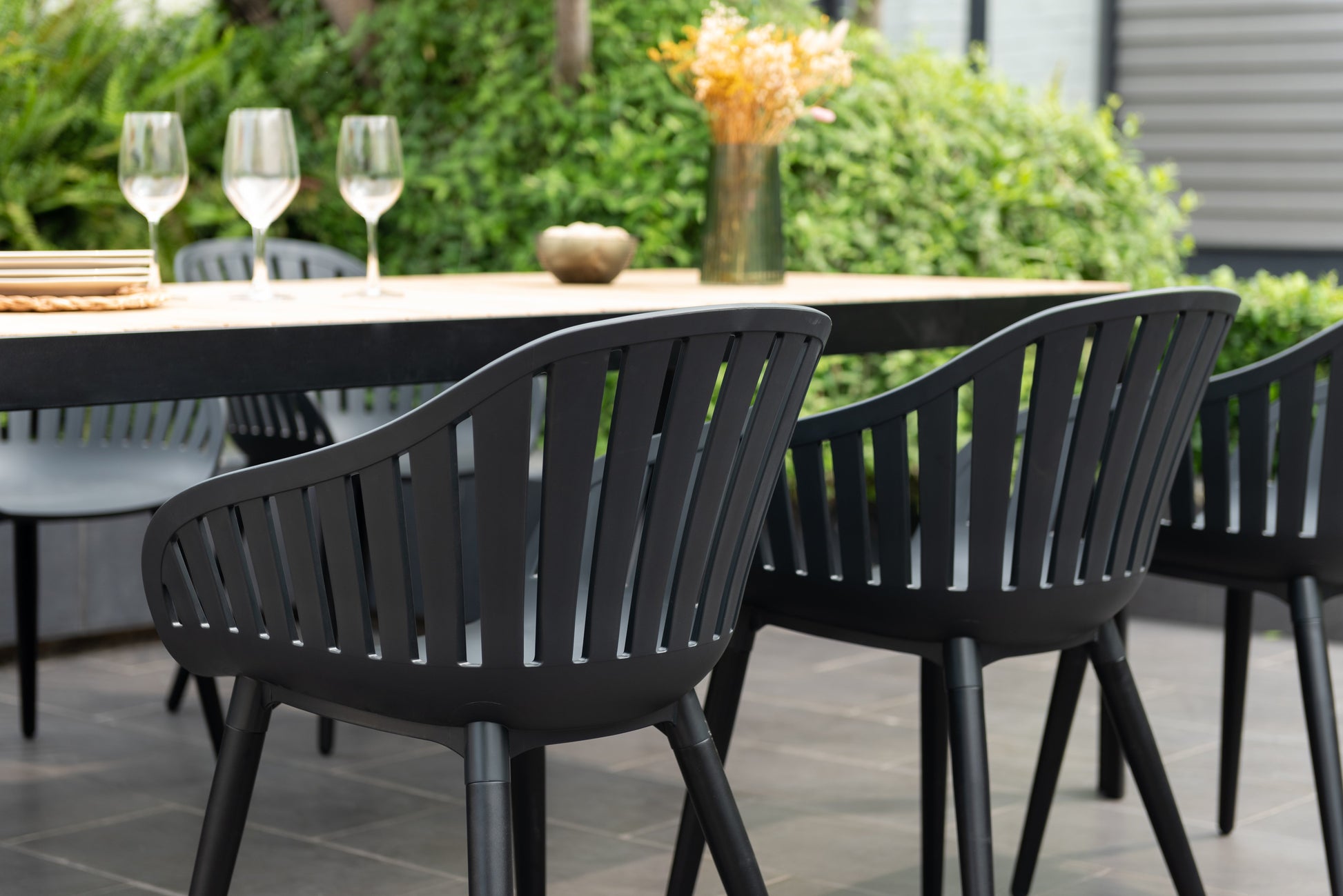 Portals dark rectangular teak table with 6 Nassau black aluminum dining chairs outdoor set on Tampa Home & Garden Store