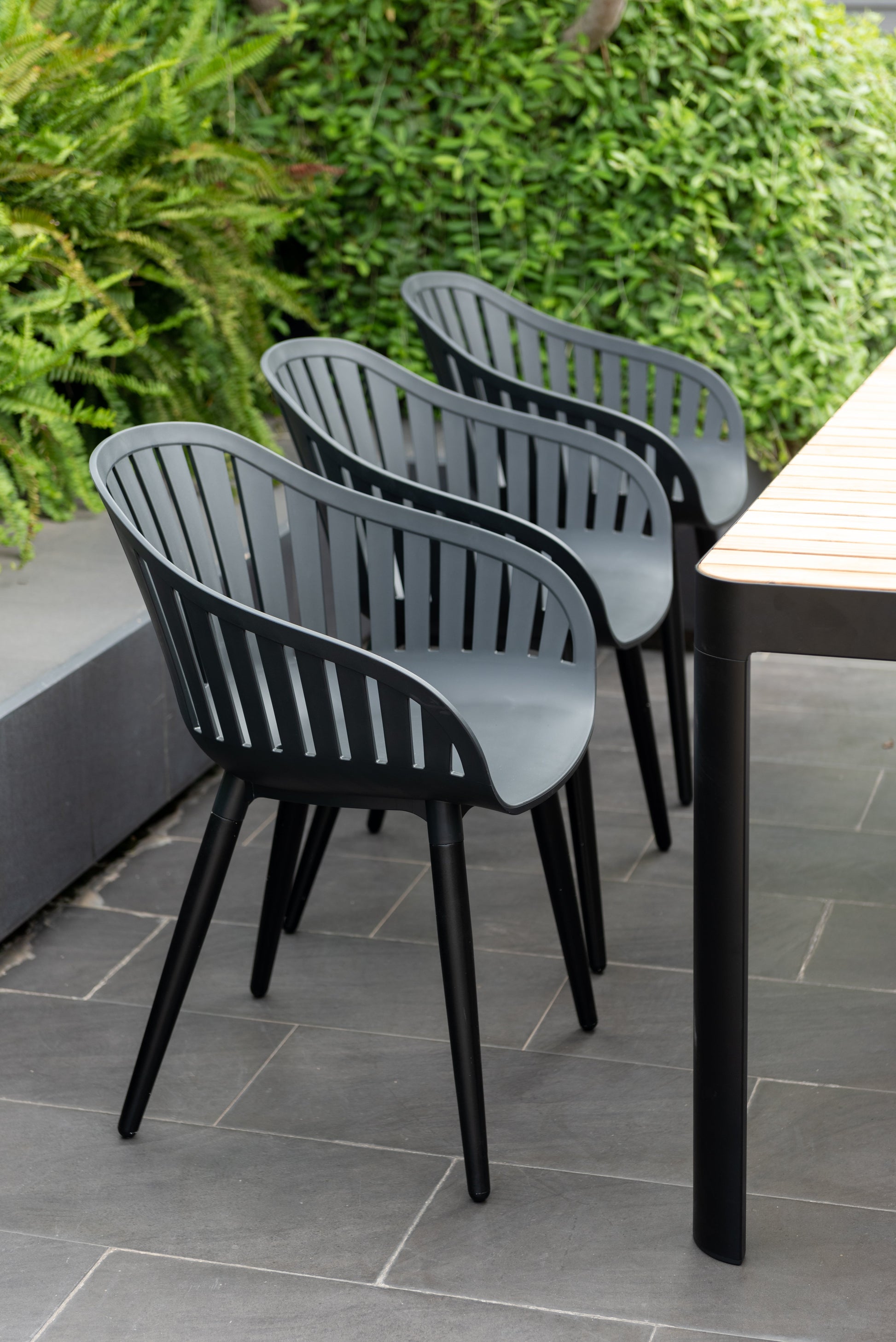 Portals dark rectangular teak dining table with 6 Nassau black aluminum chairs on Tampa Home & Garden Store