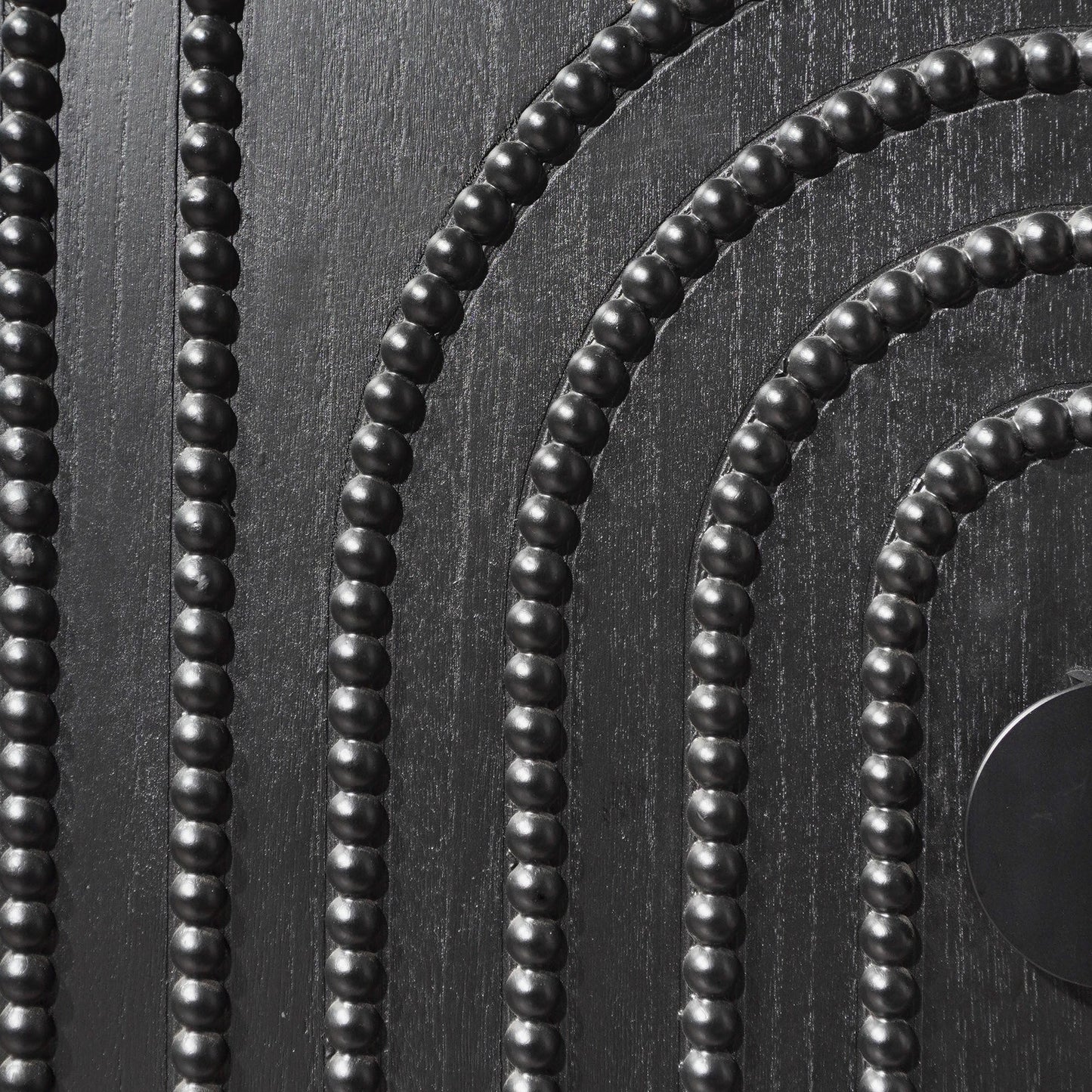 Black bead strands with round beads on textured dark wood surface on Tampa Home & Garden Store
