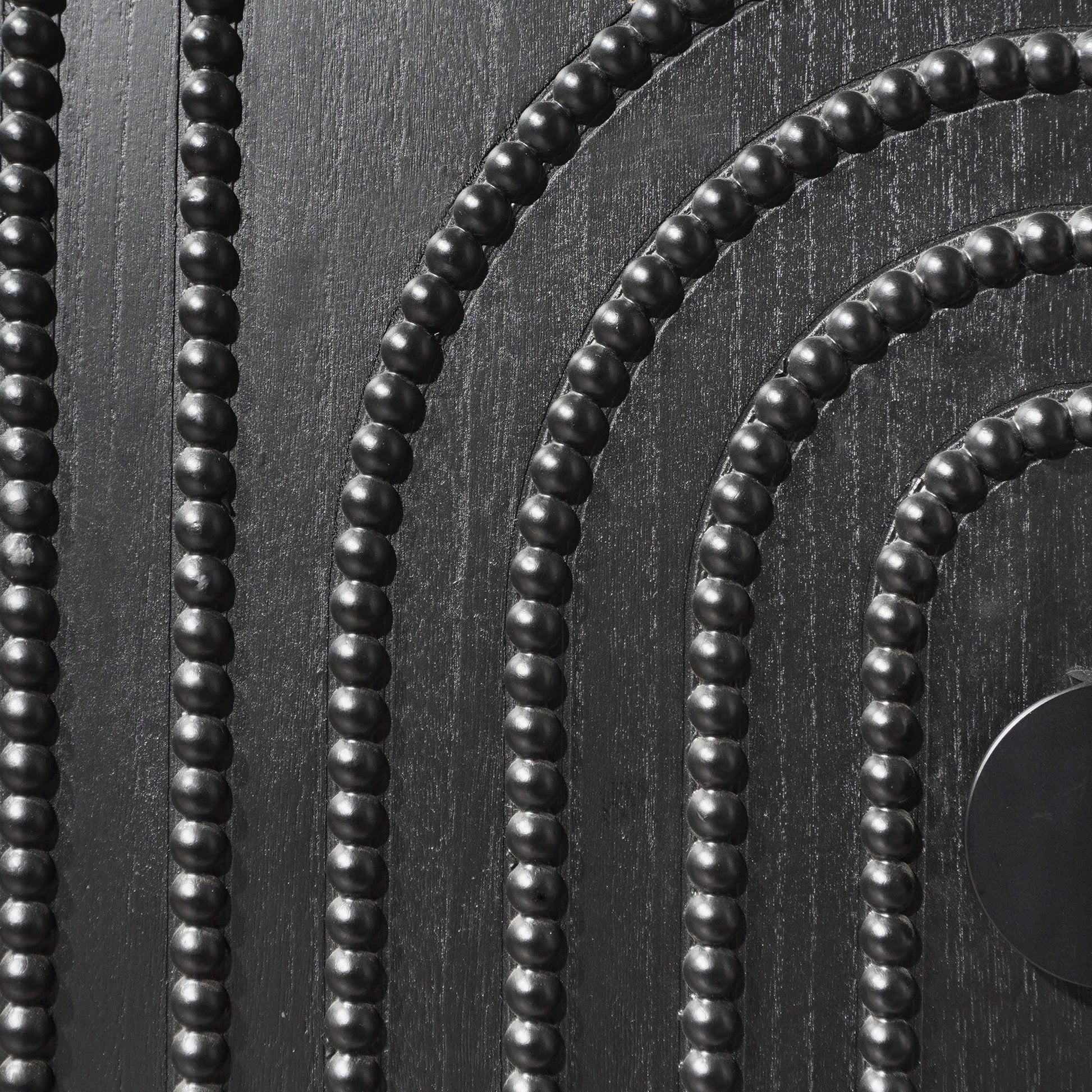 Black bead strands with round beads on textured dark wood surface on Tampa Home & Garden Store