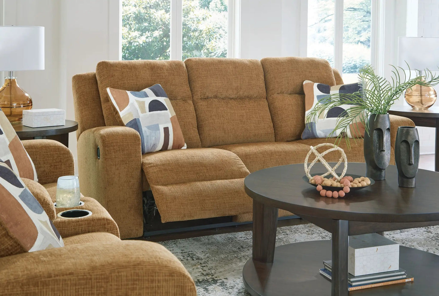 Kanlow reclining sofa in warm tan fabric with geometric pattern pillows on Tampa Home & Garden Store