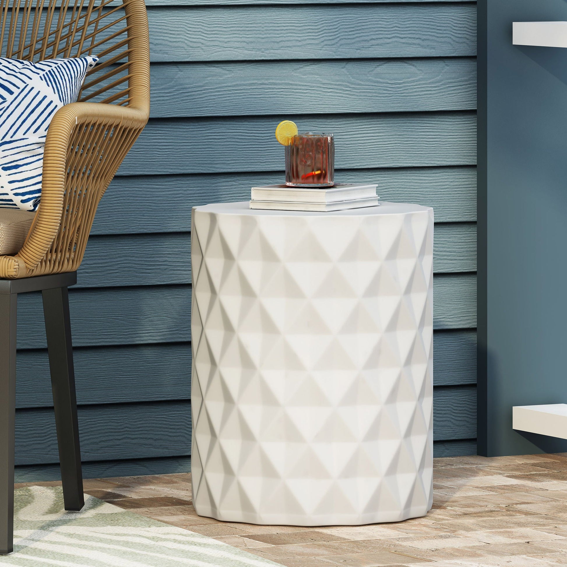 Outdoor lightweight concrete side table antique white with faceted surface beside wicker chair on Tampa Home & Garden Store