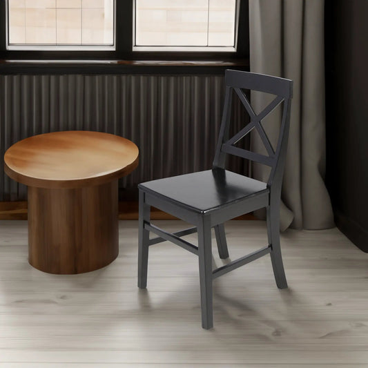 Roshan Farmhouse Acacia Wood Dining Chair in black with X-back beside round wooden table on Tampa Home & Garden Store