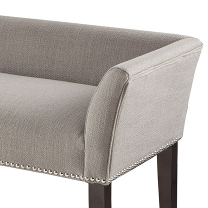 Upholstered bench in gray fabric with solid wood legs and nailhead trim on Tampa Home & Garden Store