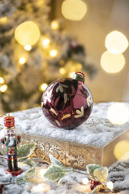burgundy glass Christmas ball ornament with gold leaf botanical design on a snow-dusted book on Tampa Home & Garden Store