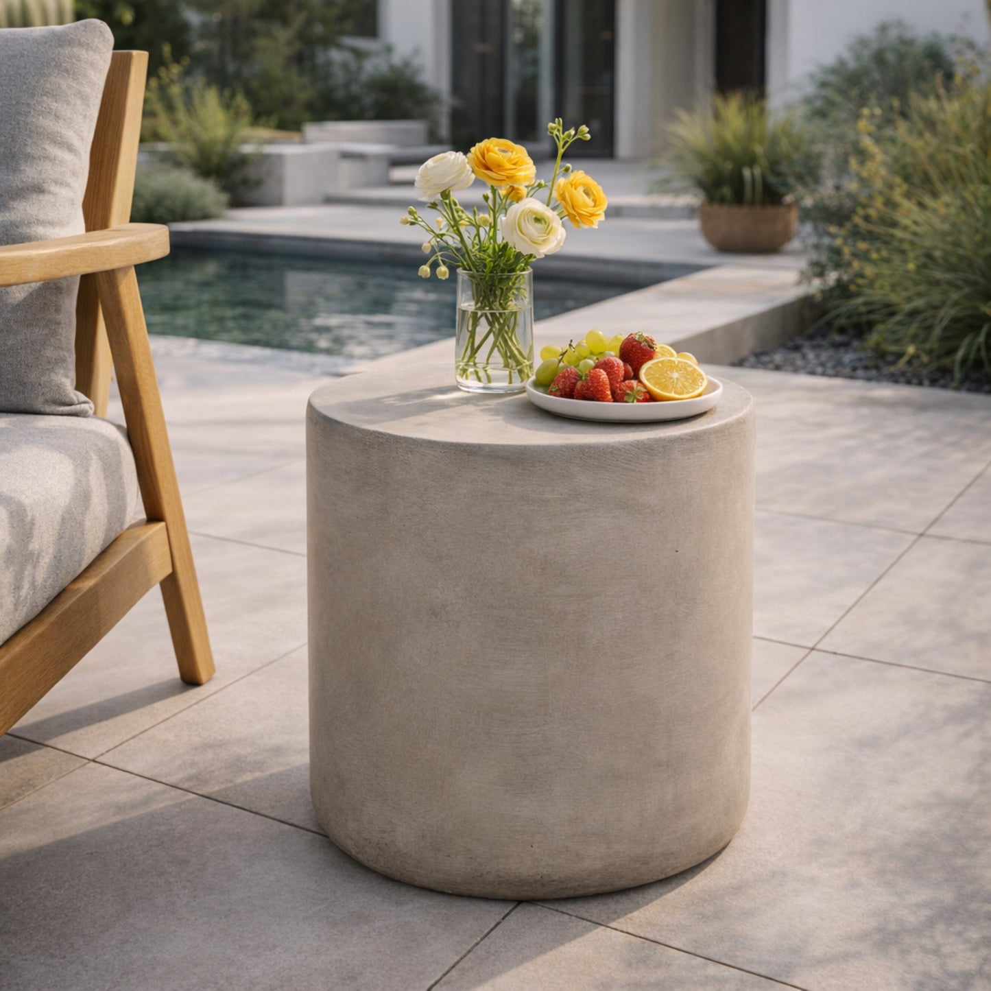 Outdoor lightweight concrete side table in light gray with vase of yellow flowers on Tampa Home & Garden Store