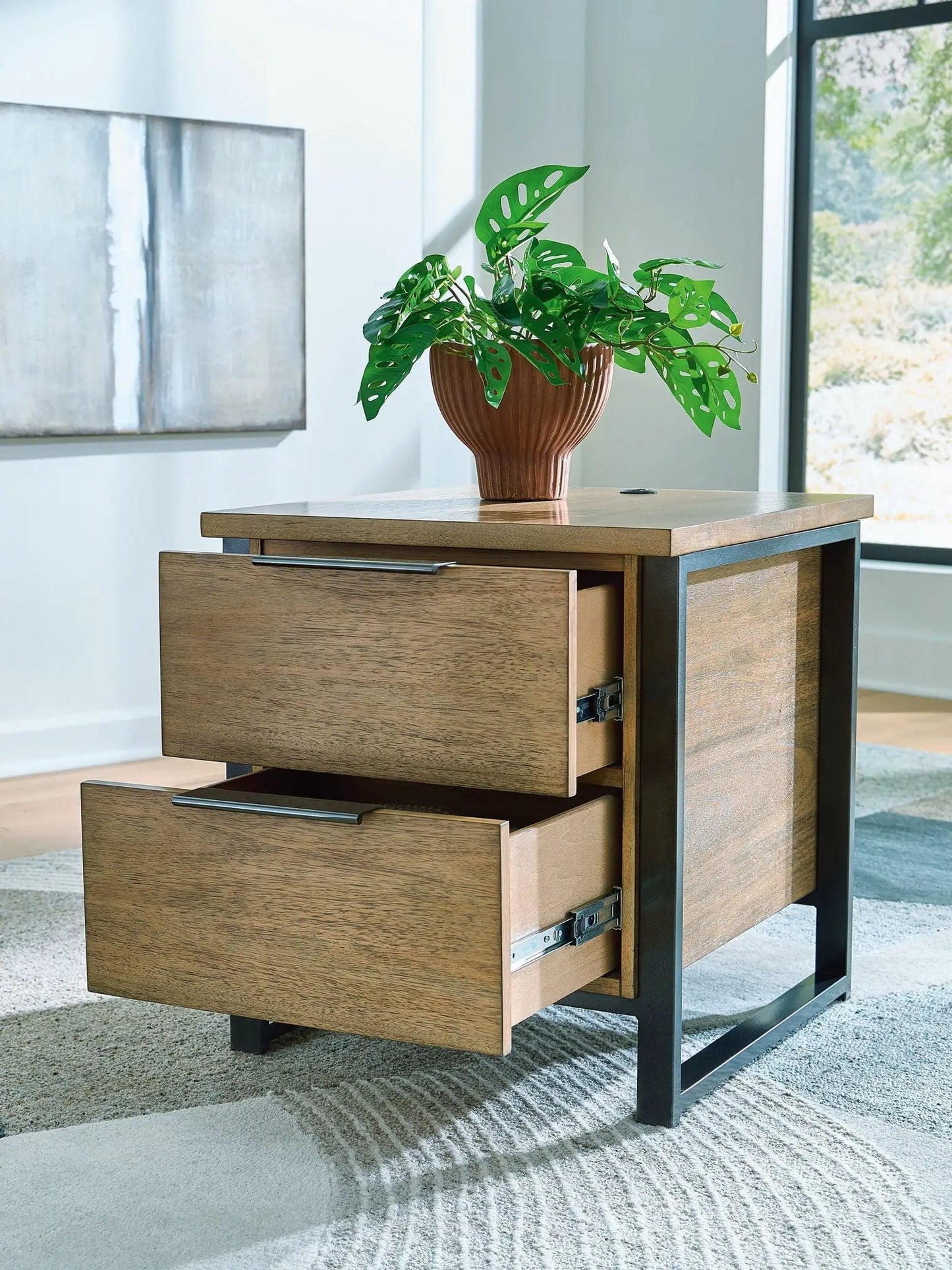 Montia cocktail table with warm wood drawers and a black metal frame on Tampa Home & Garden Store